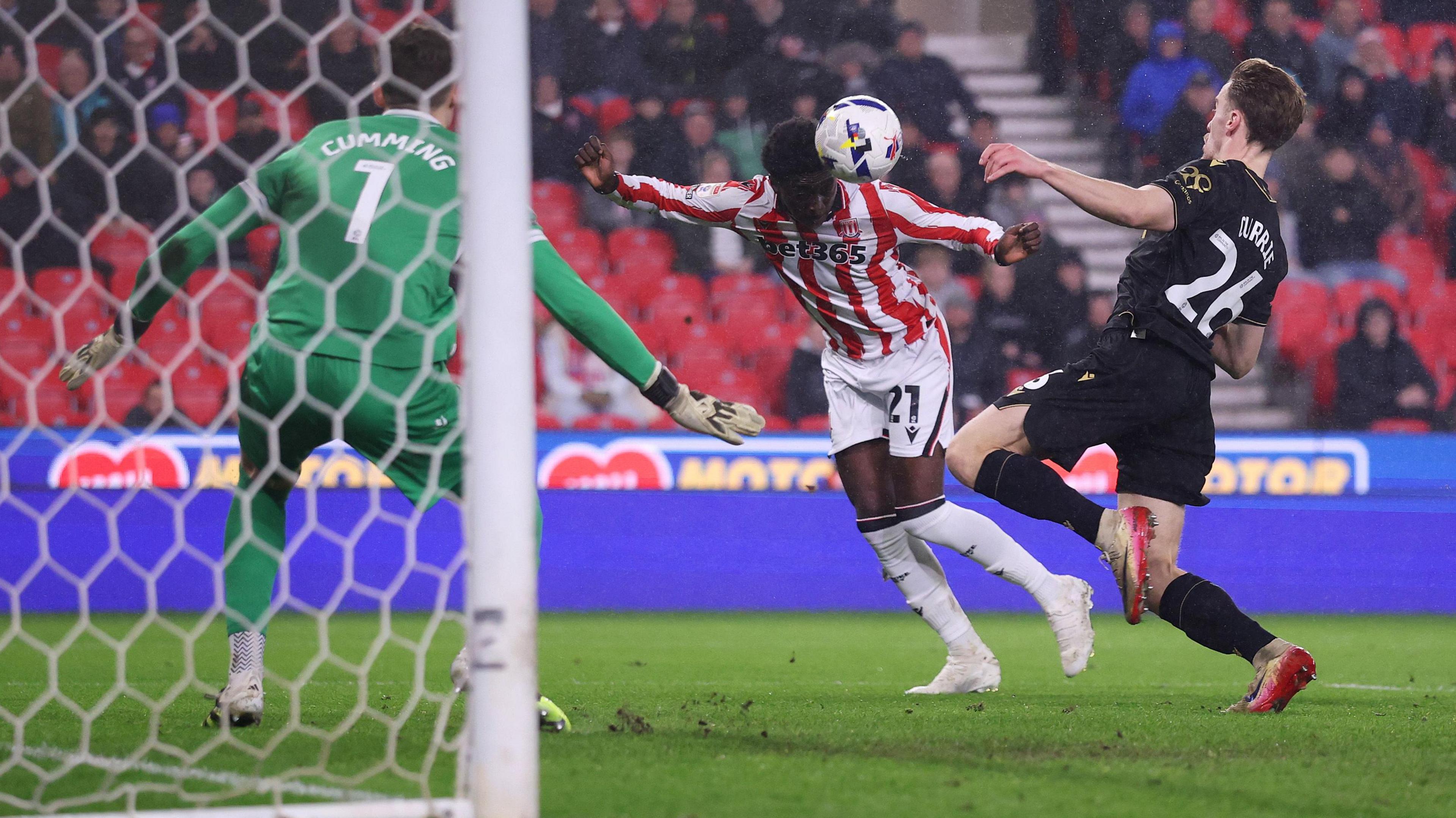 Jesurun Rak-Sakyi heads the ball across a defender and the goalkeeper