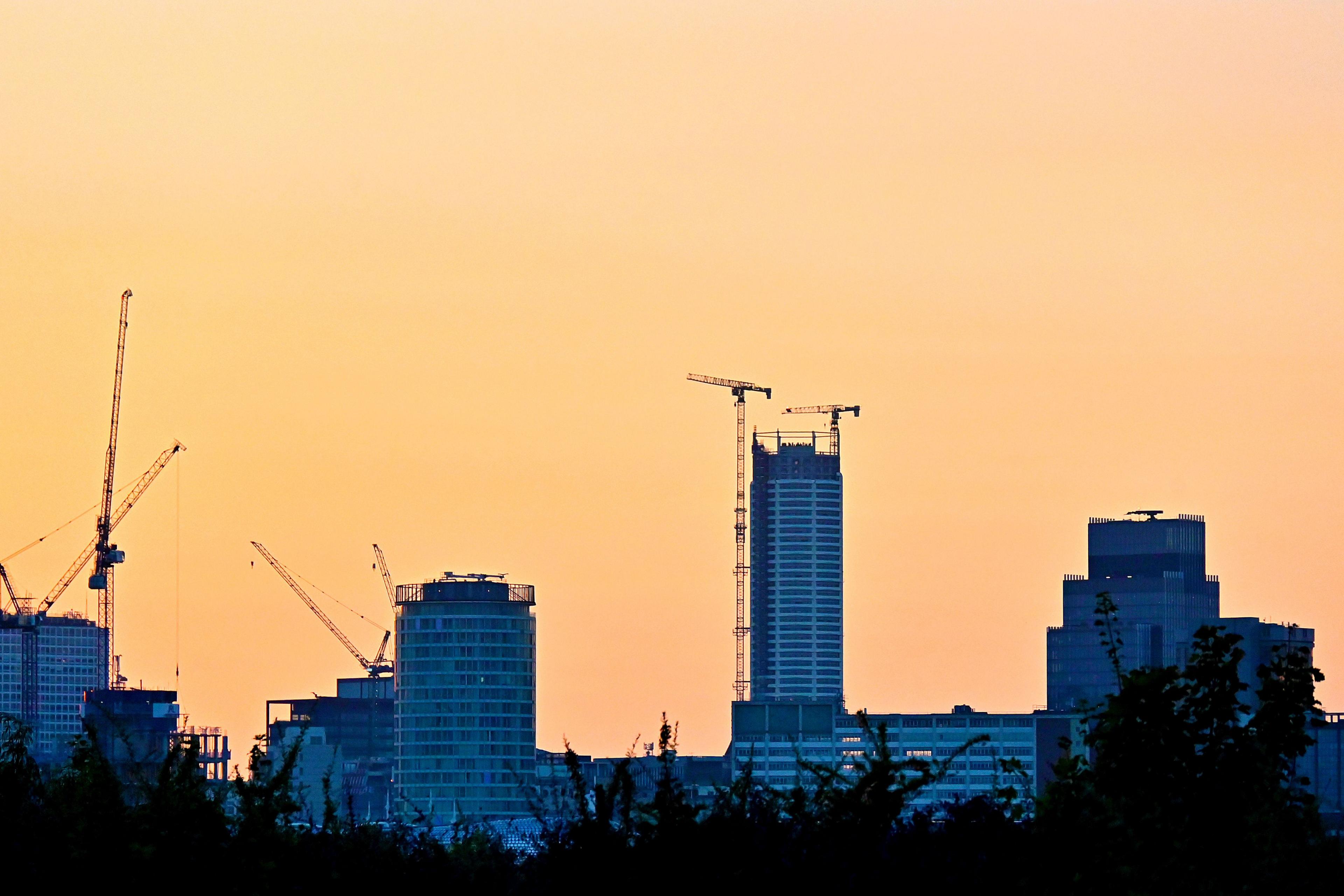 A yellow and orange sunset sky overlooking a skyline of buildings 