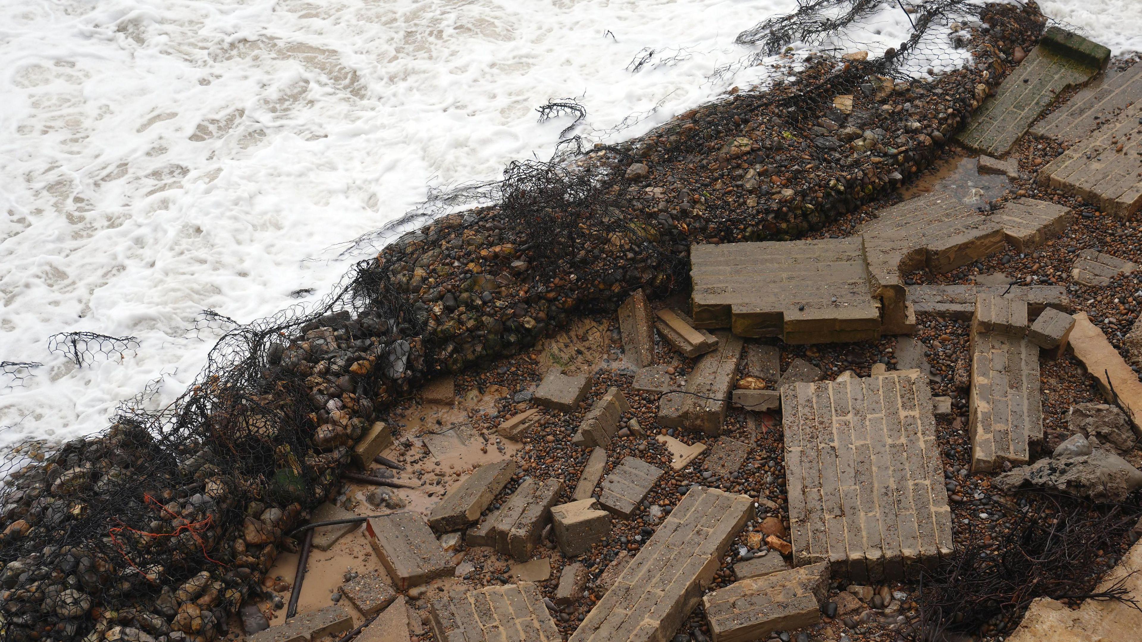 A view from above of Ms Flick's wall that has fallen on to the beach below and been destroyed.