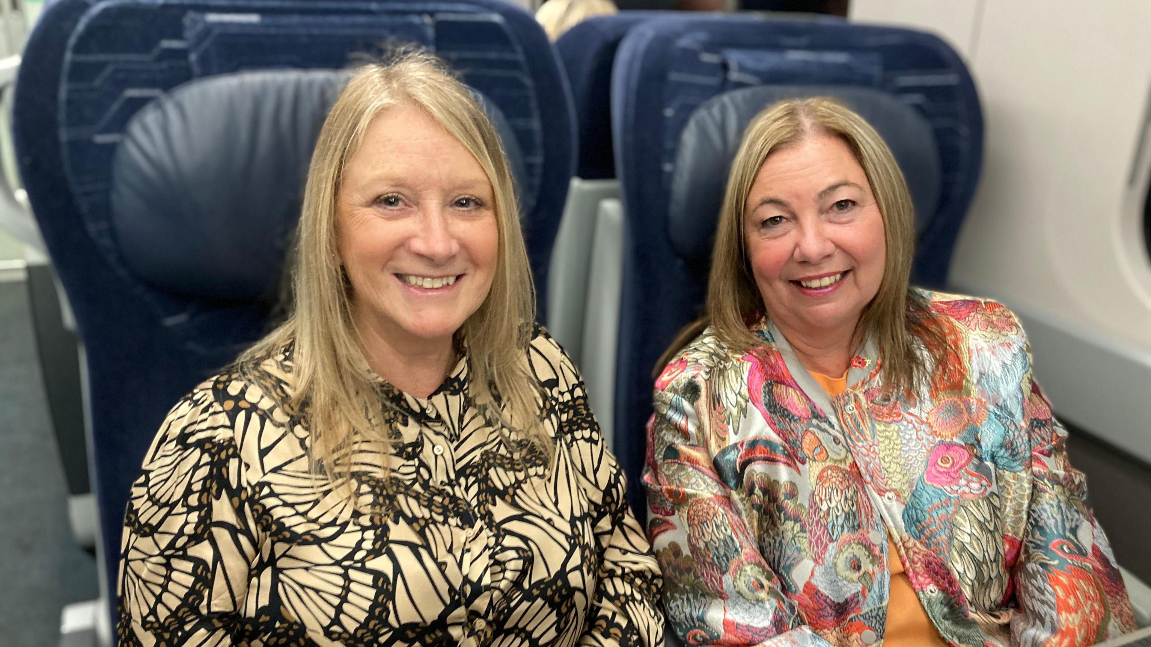 Friends Helen Ackroyd and Liz Turner sitting next to each other on the train.