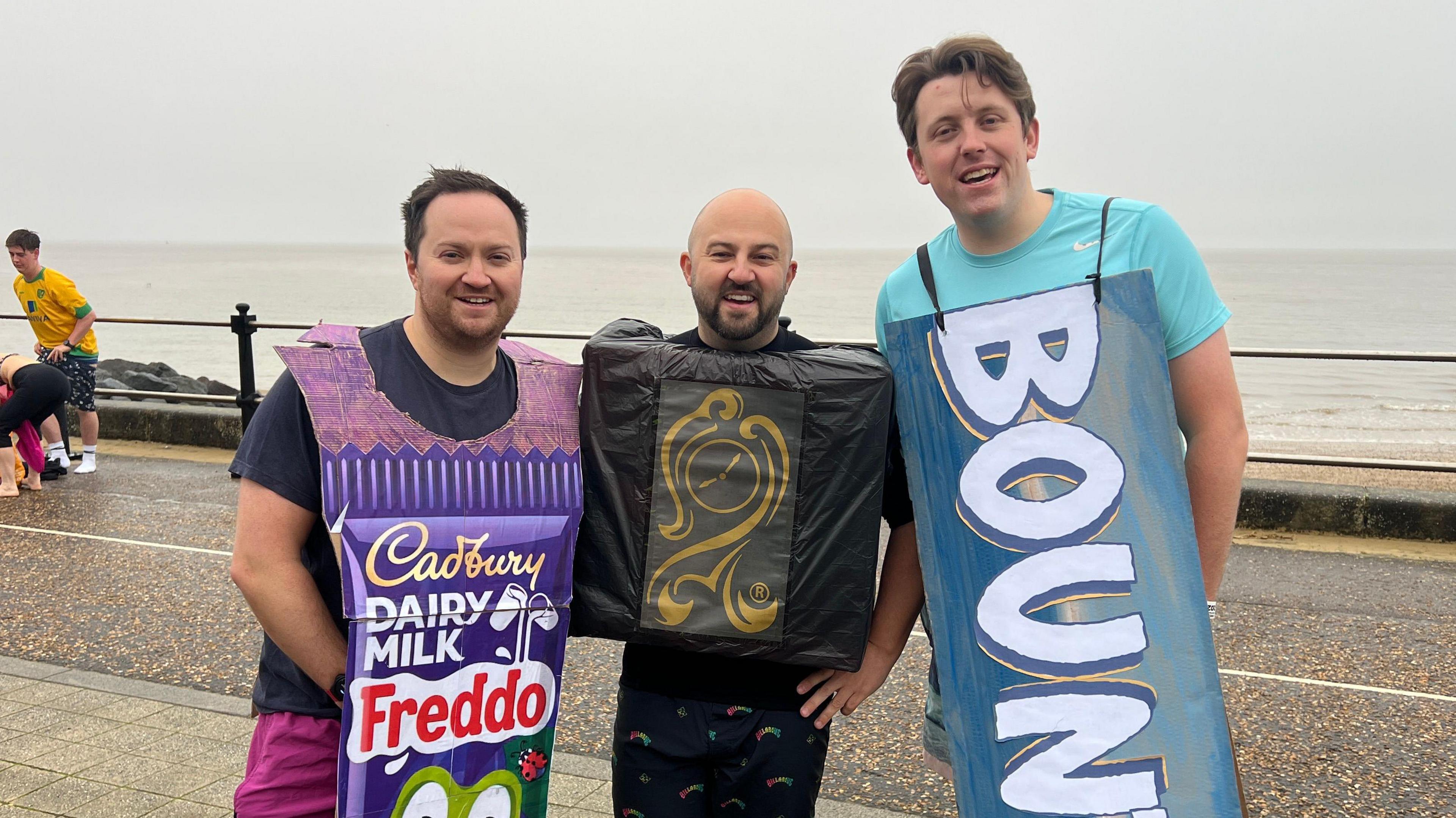 Three men in fancy dress, posed and looking at the camera after taking part in the Christmas Day swim in Lowestoft 