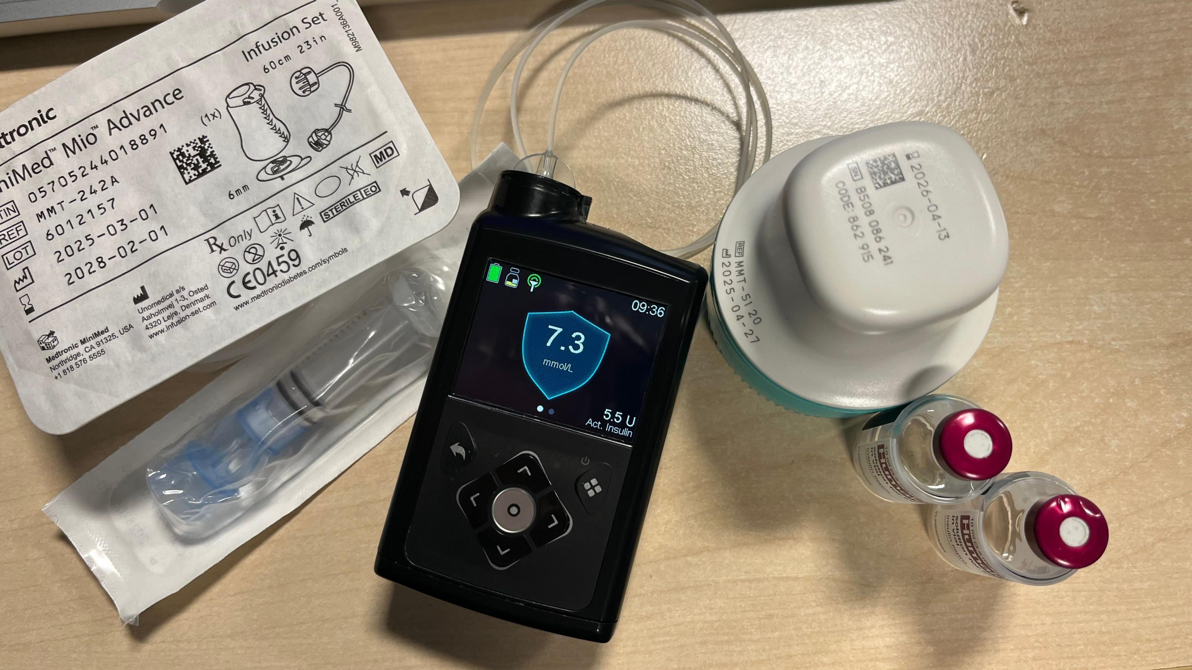 Dealbh a' sealltainn pumpa insulin, sensor, reservoir agus seata infusion airson pumpa insulin, botail bheaga de dh'insulin