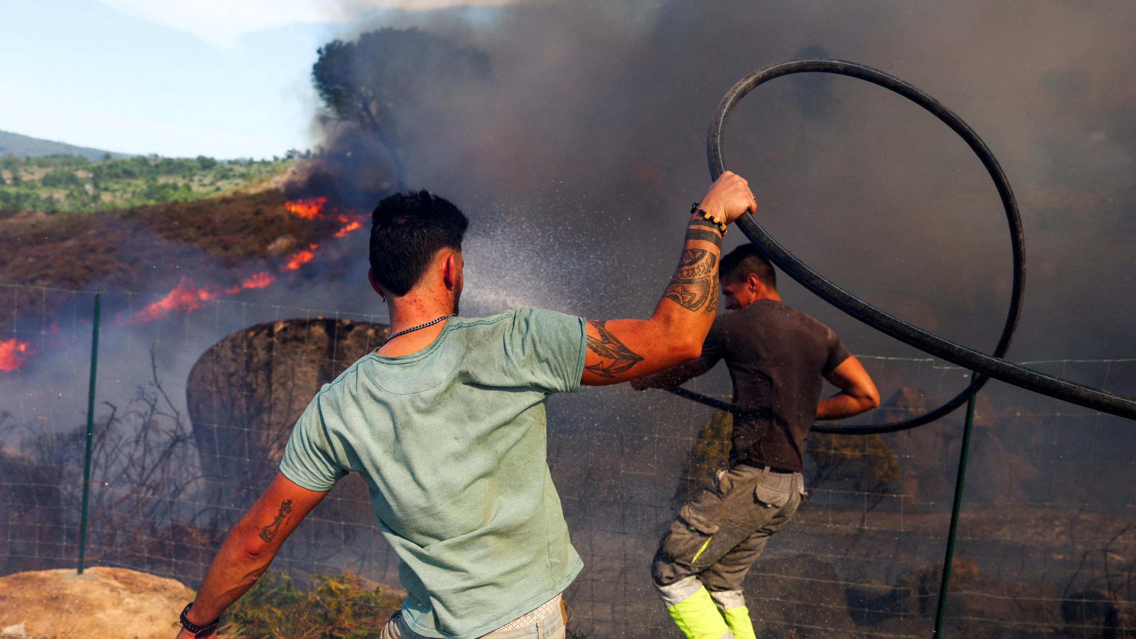 Locals try to extinguish a wildfire in Penalva do Castelo, Portugal