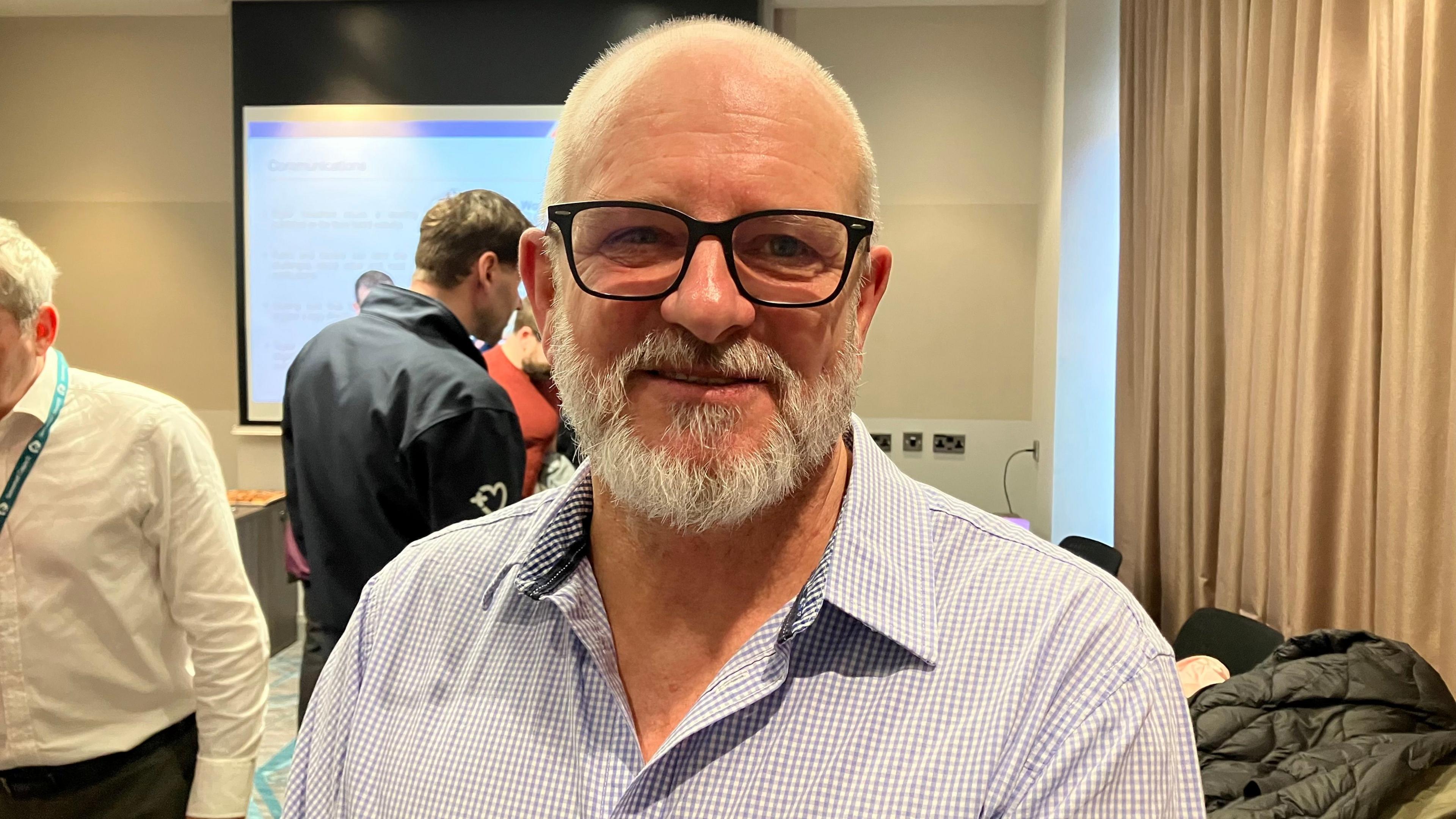 Stuart Martin looking at the camera in a hotel conference room