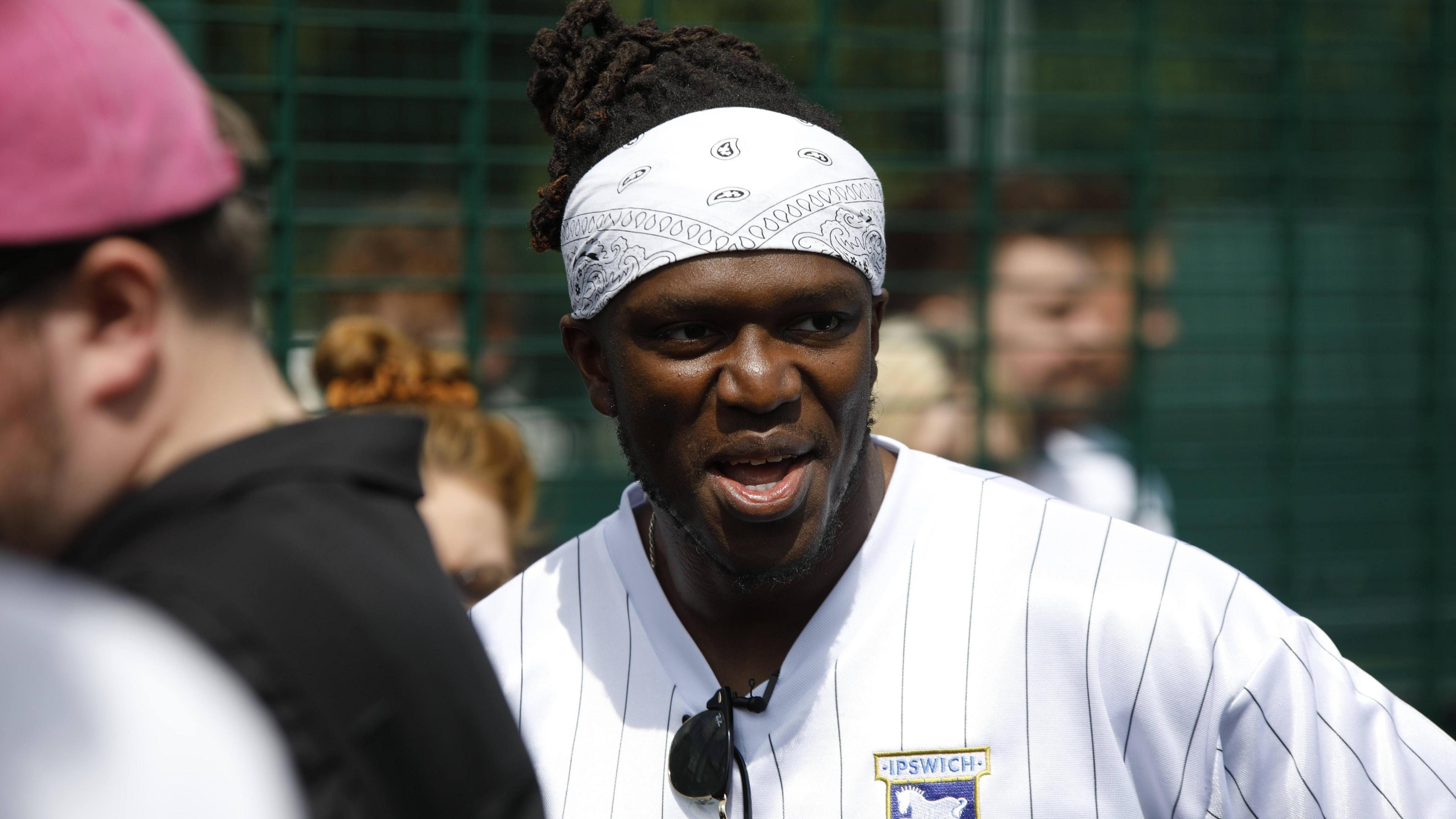 KSI wearing a white Ipswich Town Football Club top and white bandanna.