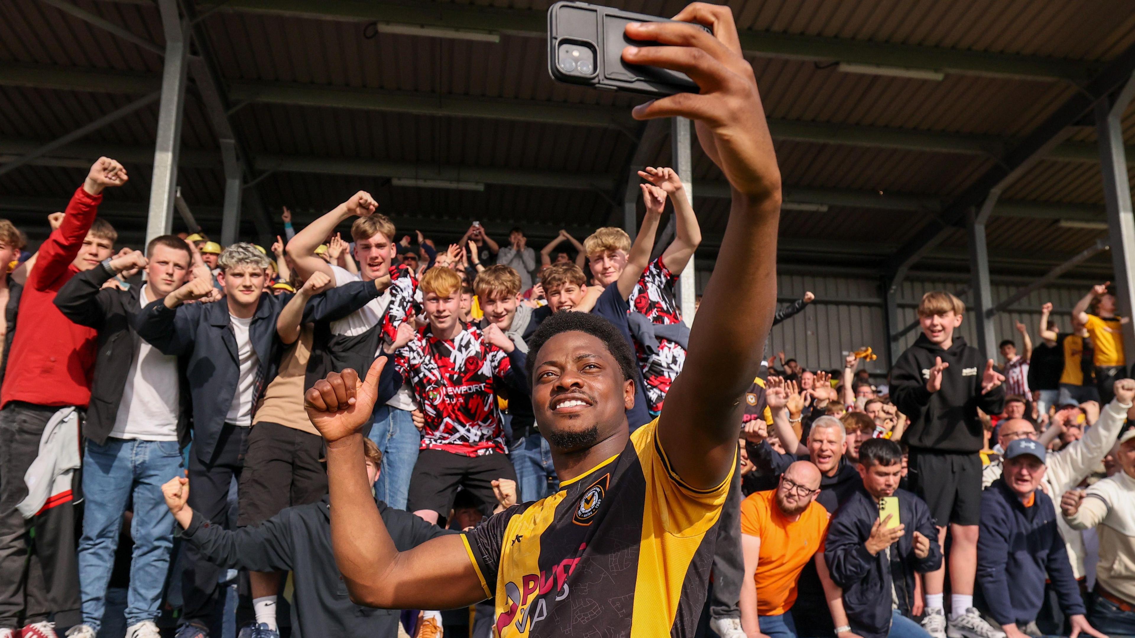 Bobby Kamwa takes a selfie with Newport's fans at Barrow