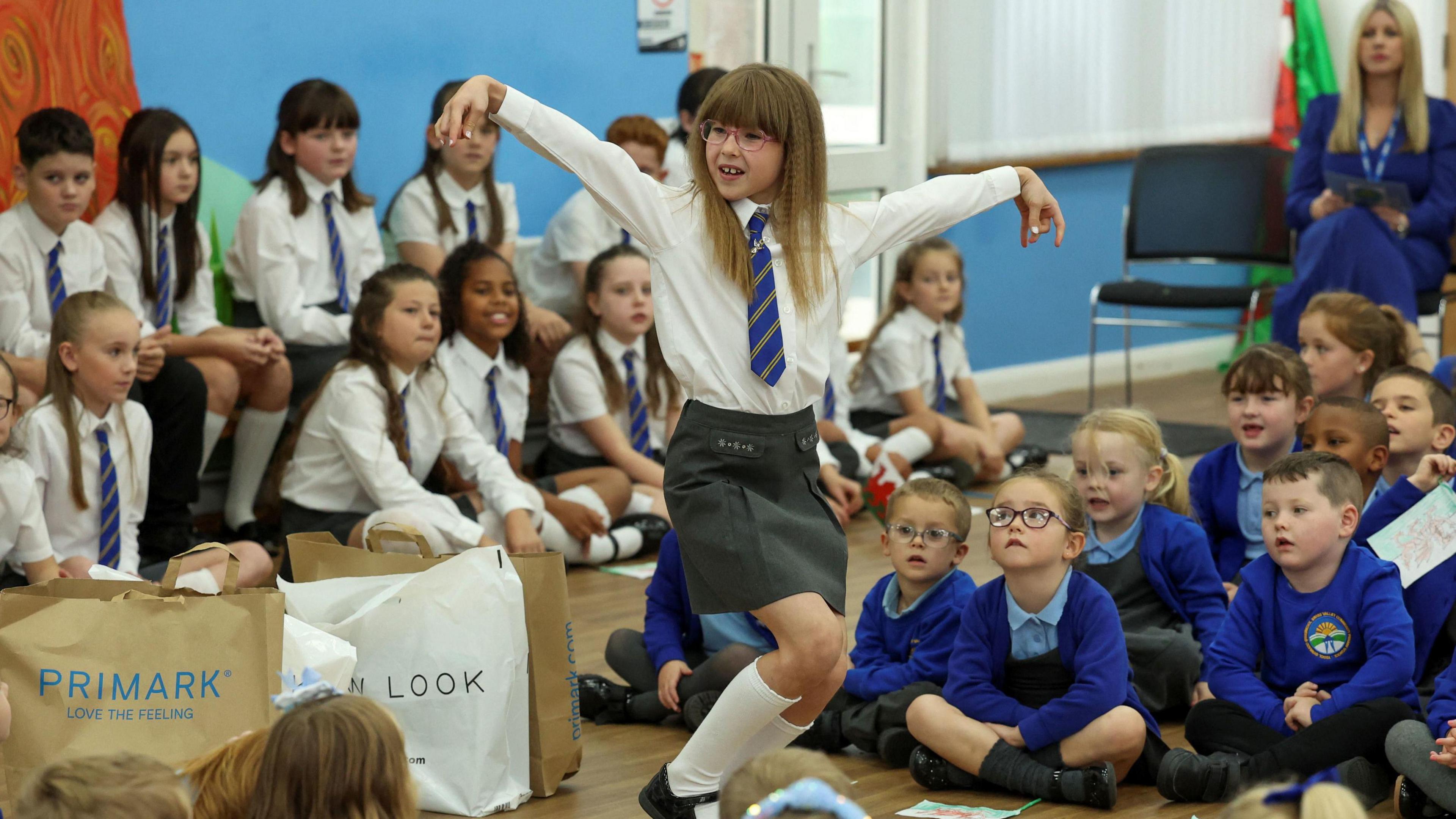 Pupil Ruby Davies dances for the Prince of Wales as pupils look on