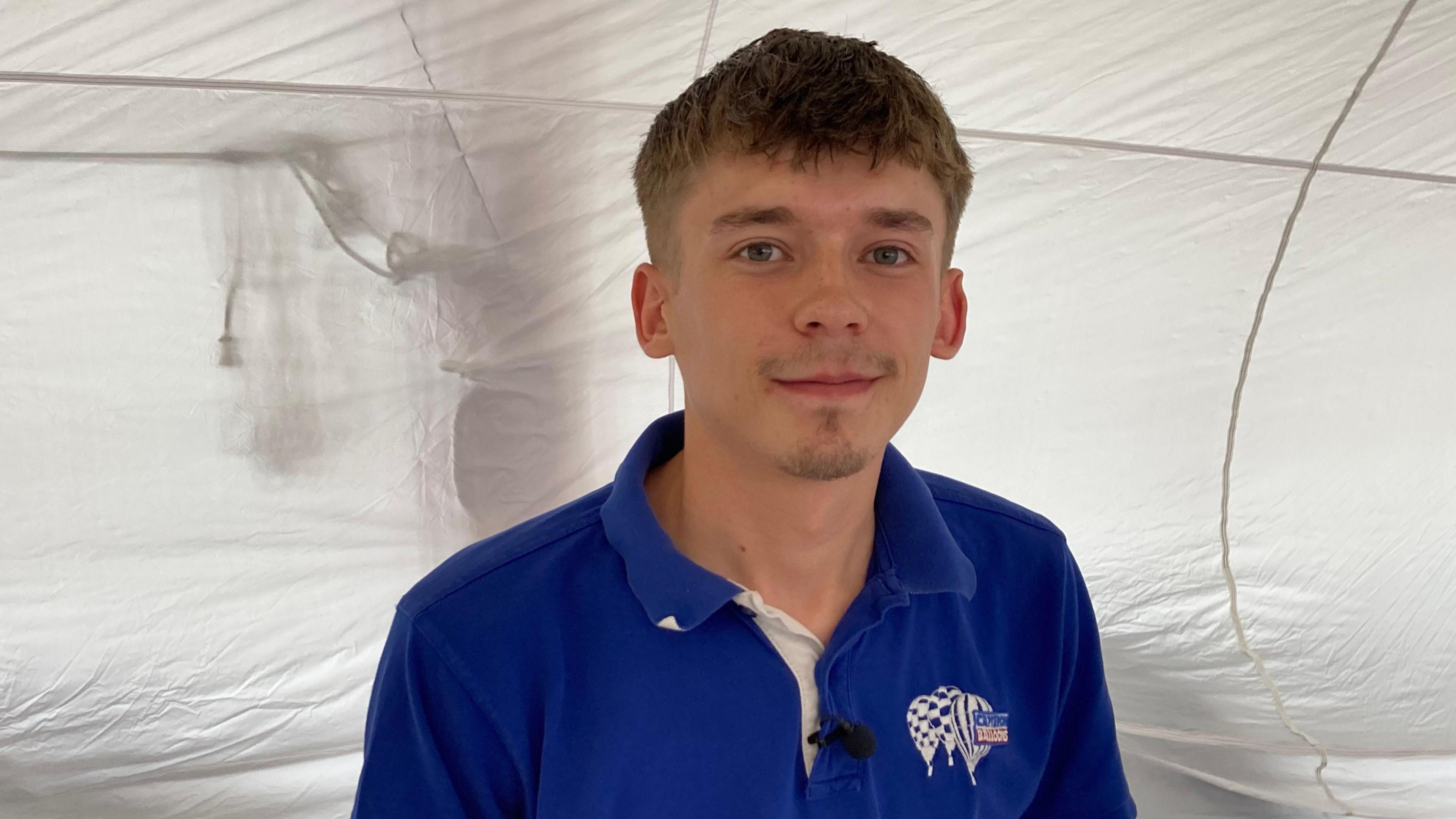 Cam Dunnington in a Cameron Balloons blue top, with white balloon silks behind him.