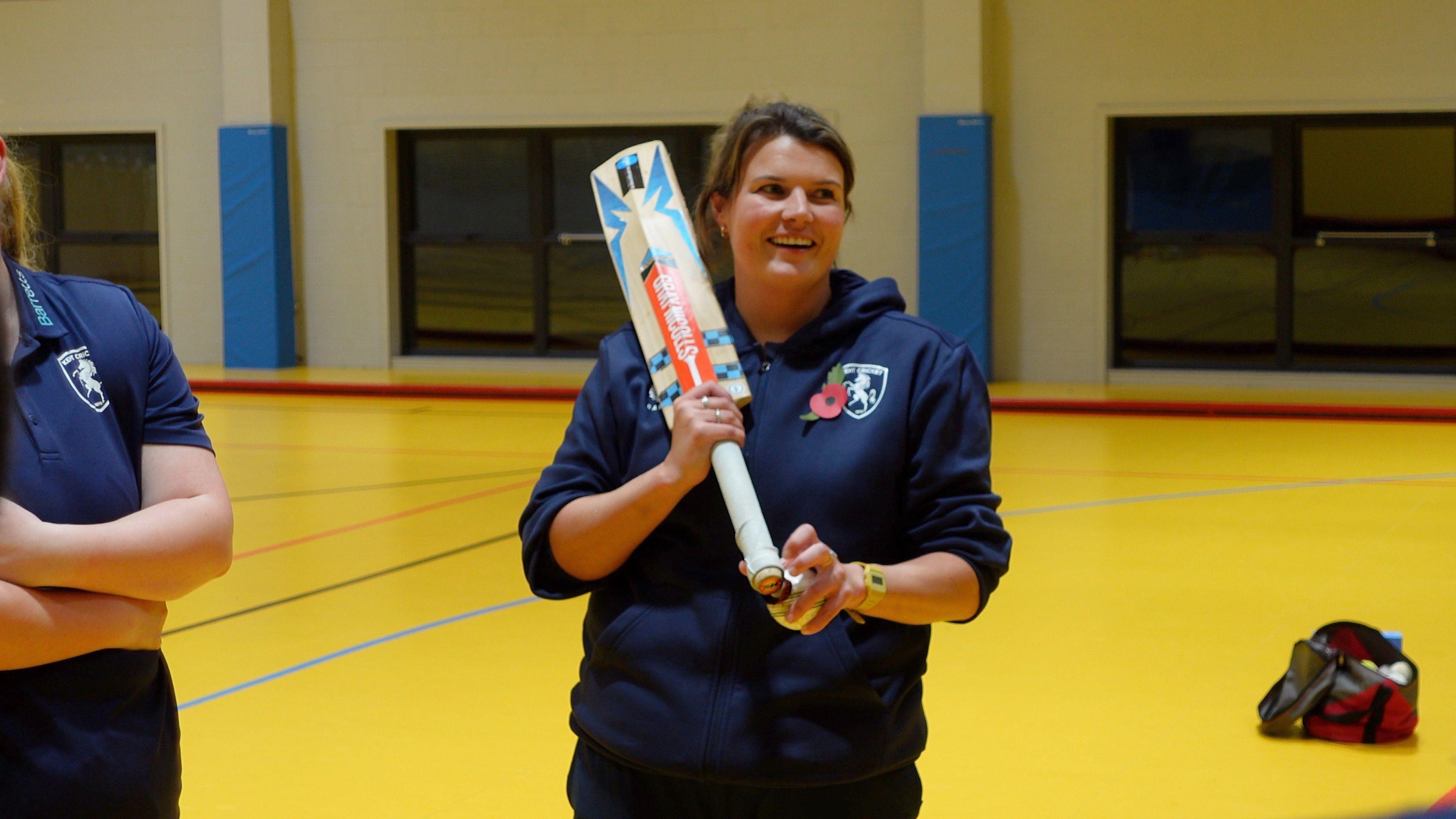 Lucy Arman holds a cricket bat 