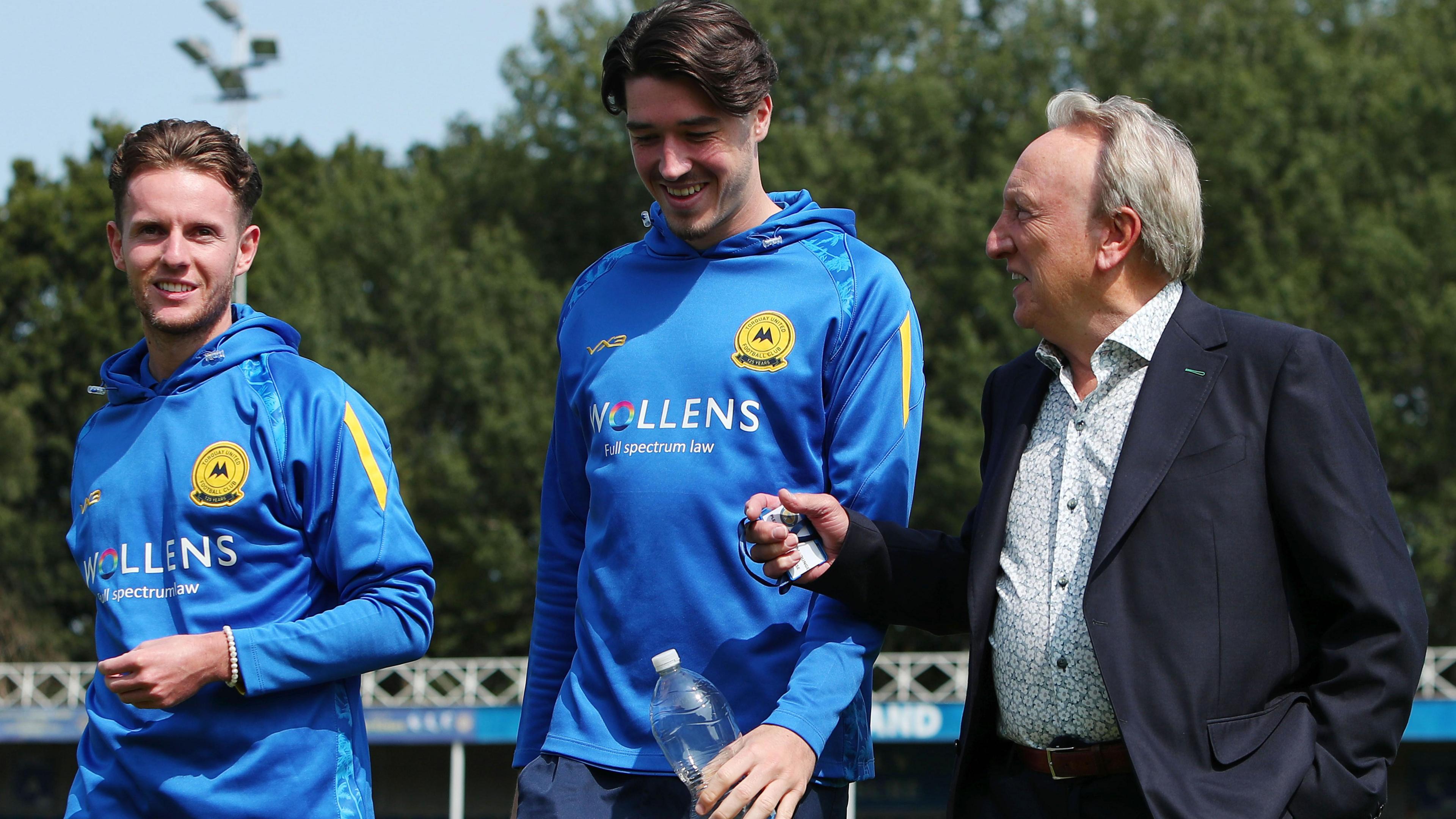 Neil Warnock chats to Torquay players before a match