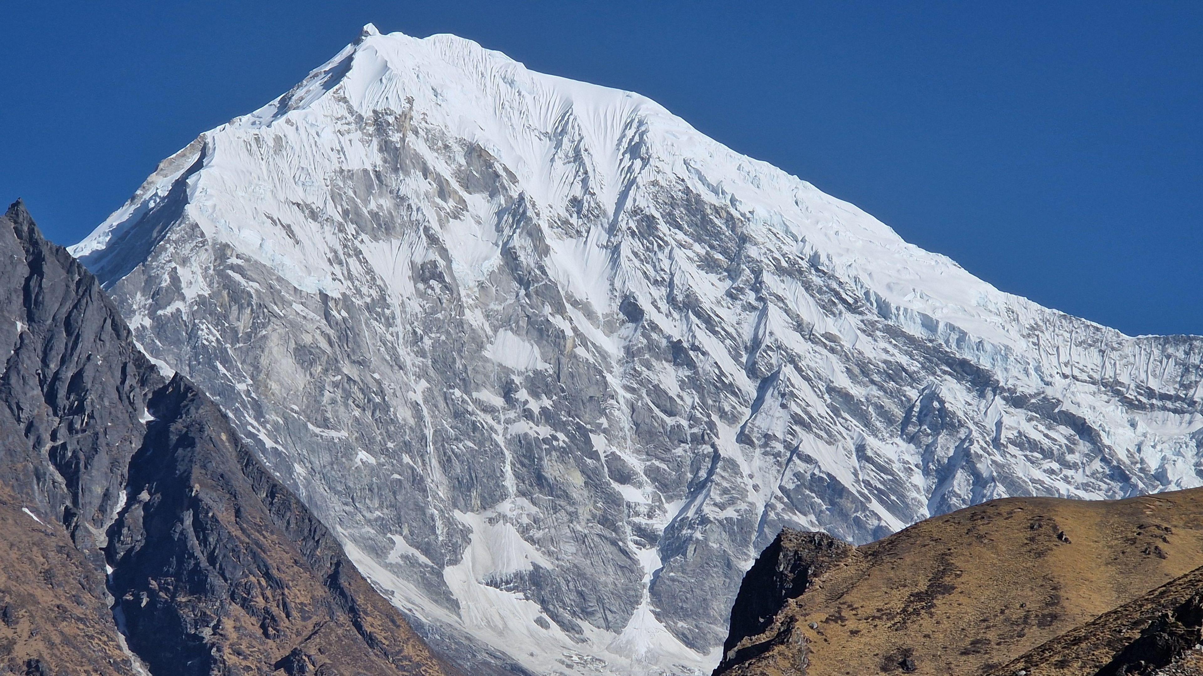 The mountain, which is completely covered in snow at the peak and then grey and white further down the slope