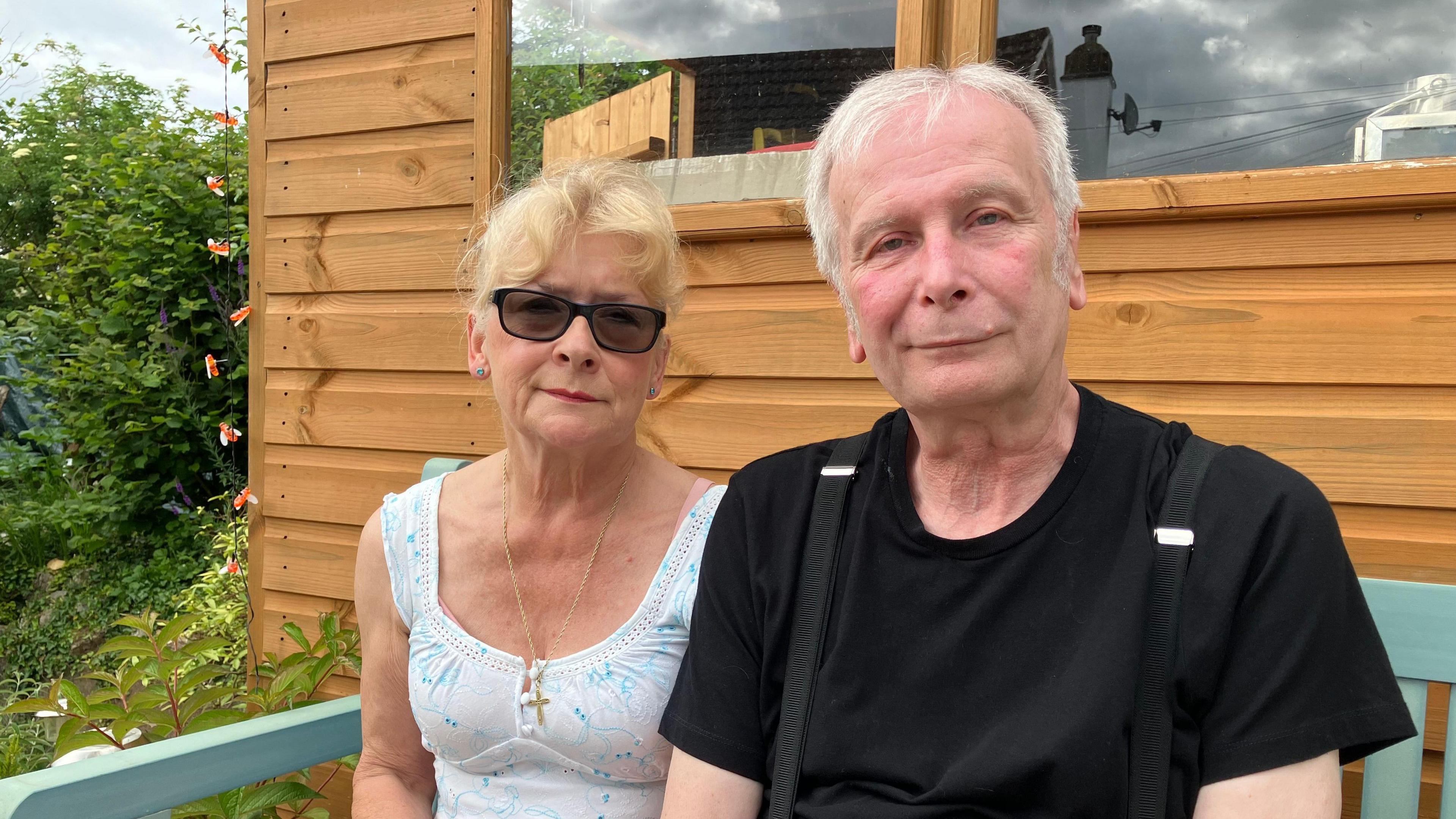 Couple sitting on a garden bench. 