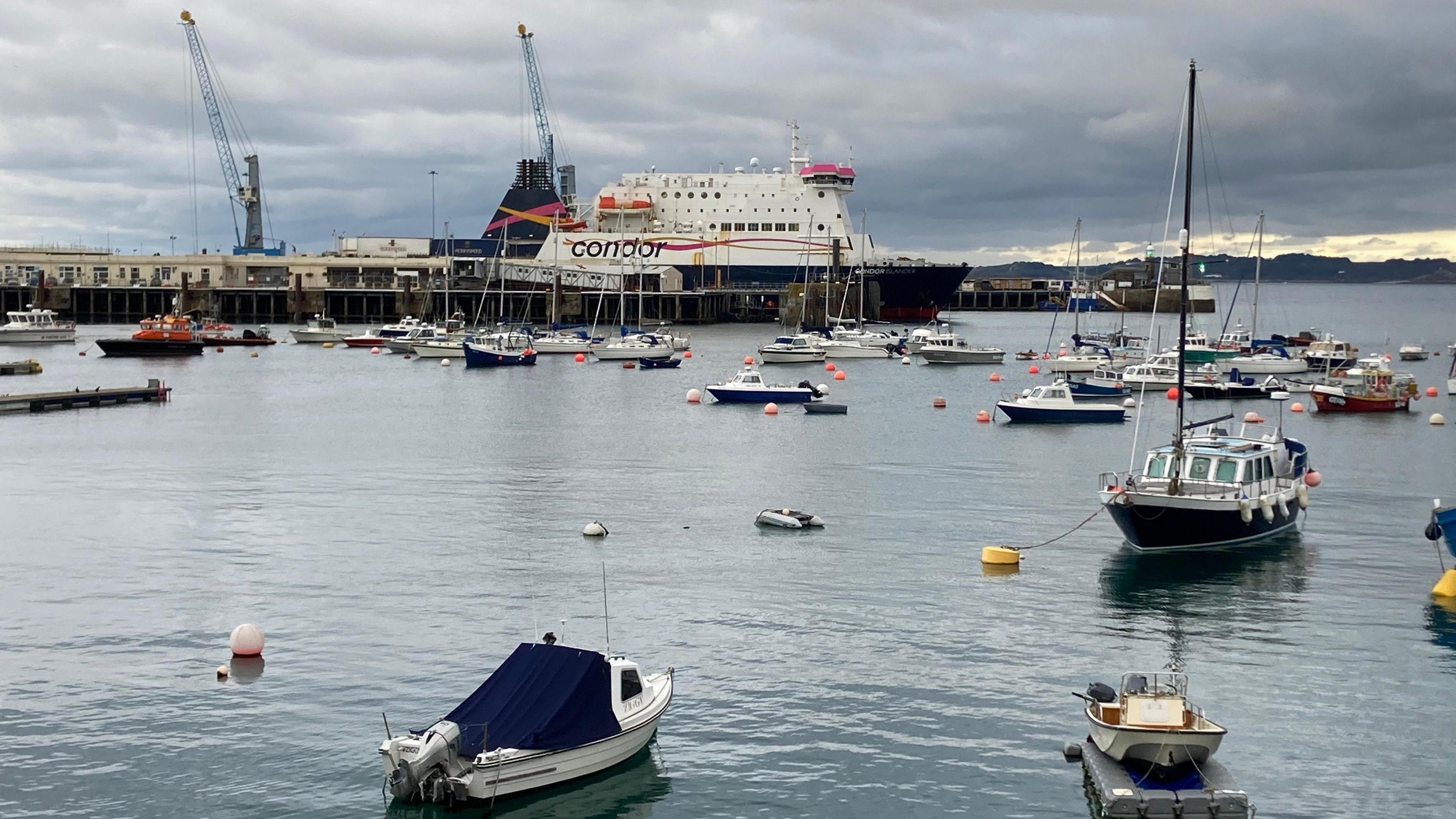 Ferry docked in St Peter Port Harbour with lots of smaller vessels in the foreground.