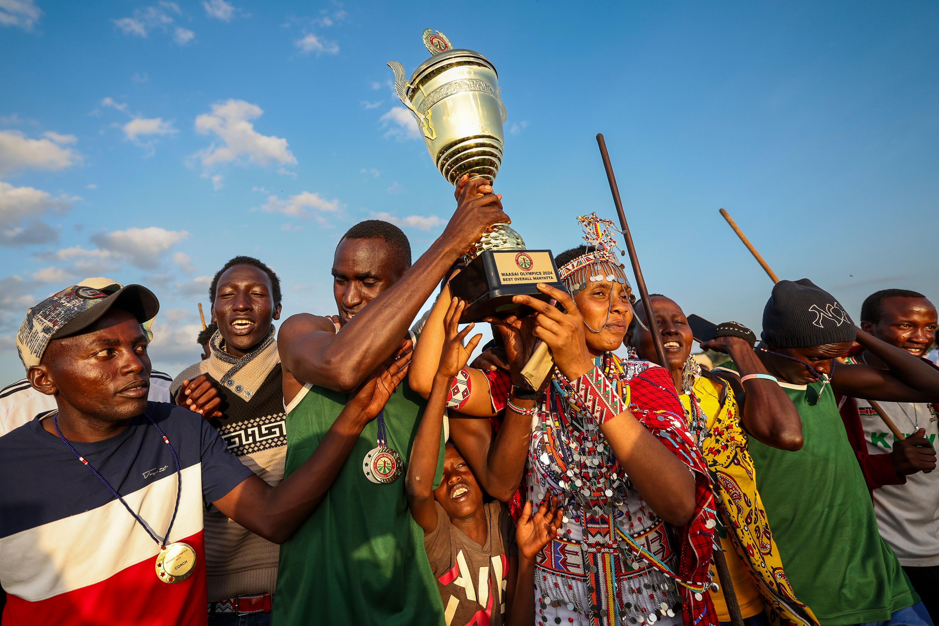 The winners hold the trophy up as they celebrate being the overall winners at a social sporting event dubbed the Maasai Olympics 2024 - Saturday 14 December 2024