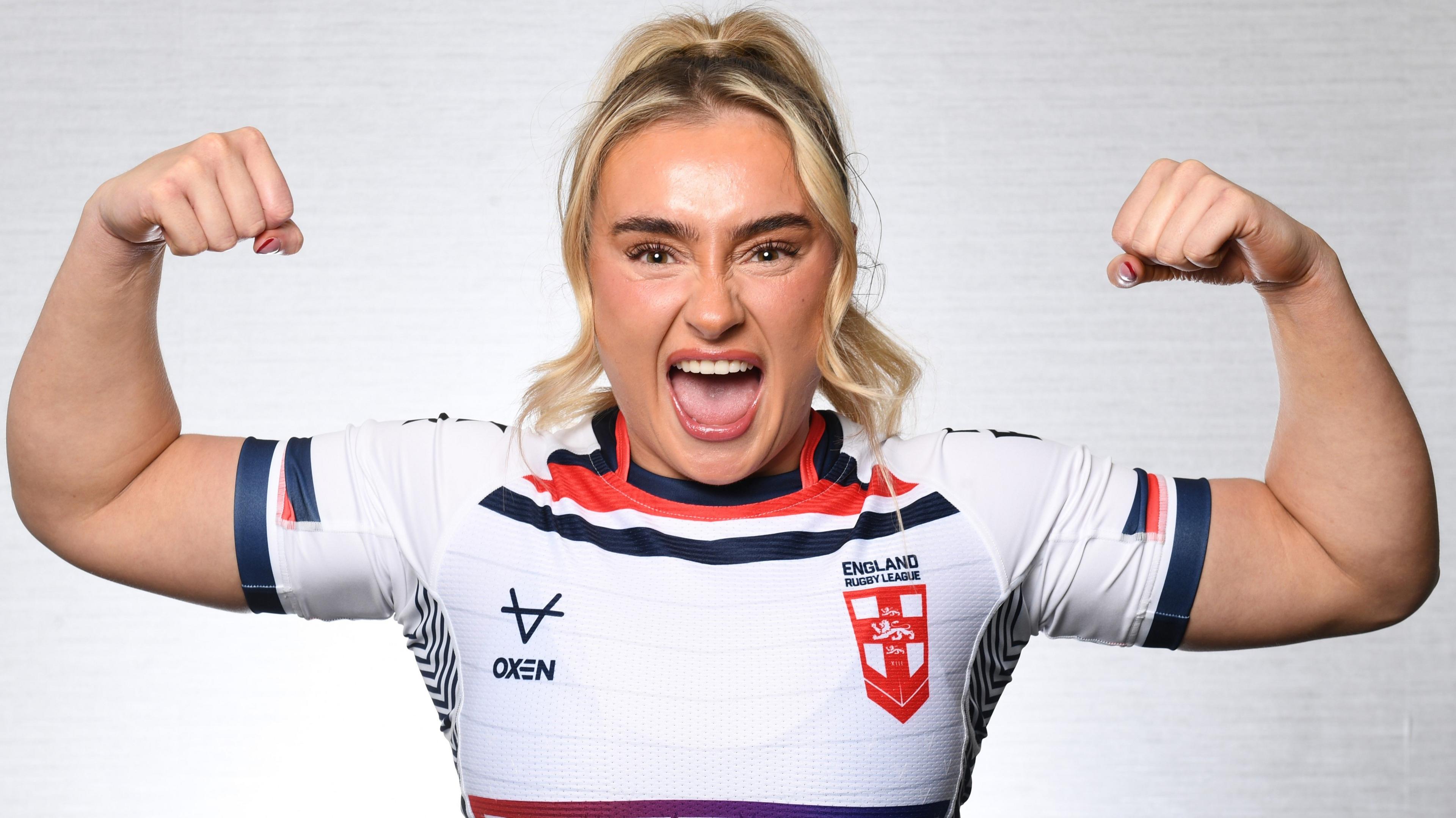 Paige Travis in an England shirt, gesturing towards the camera