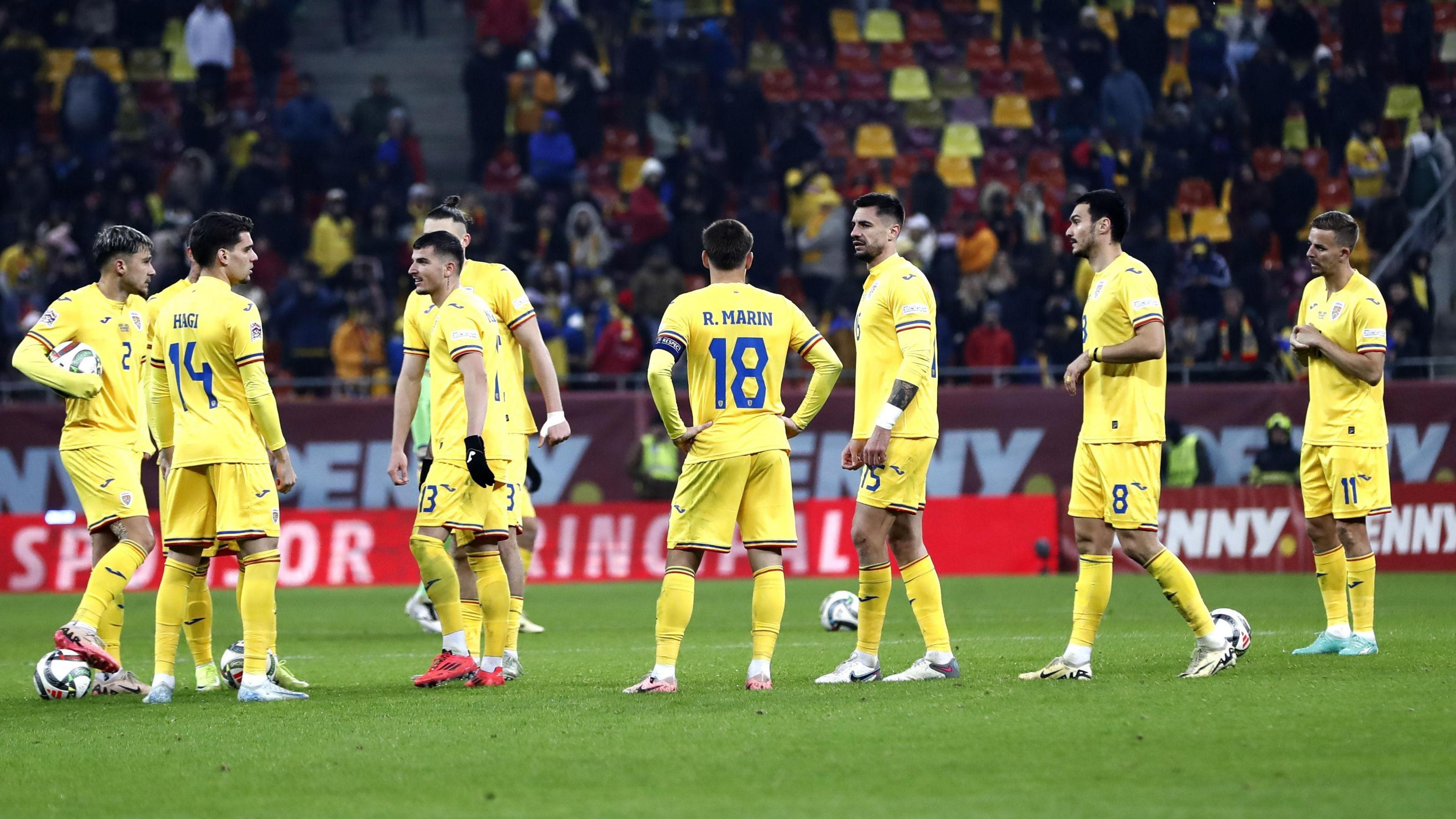 Romania players wait on the pitch