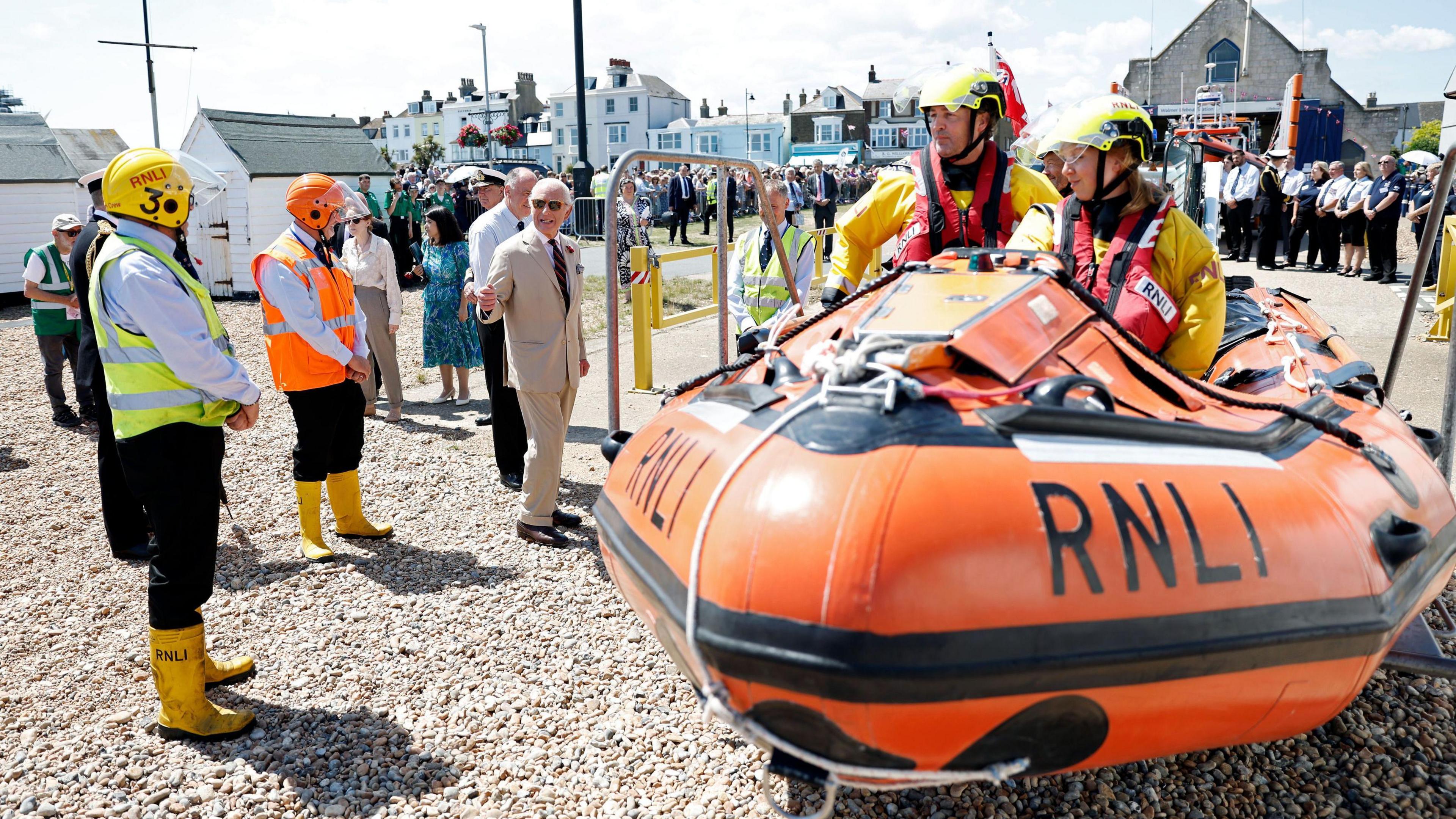 King Charles at RNLI lifeboat station talking to the crew with an inflatable RNLI boat in the foreground