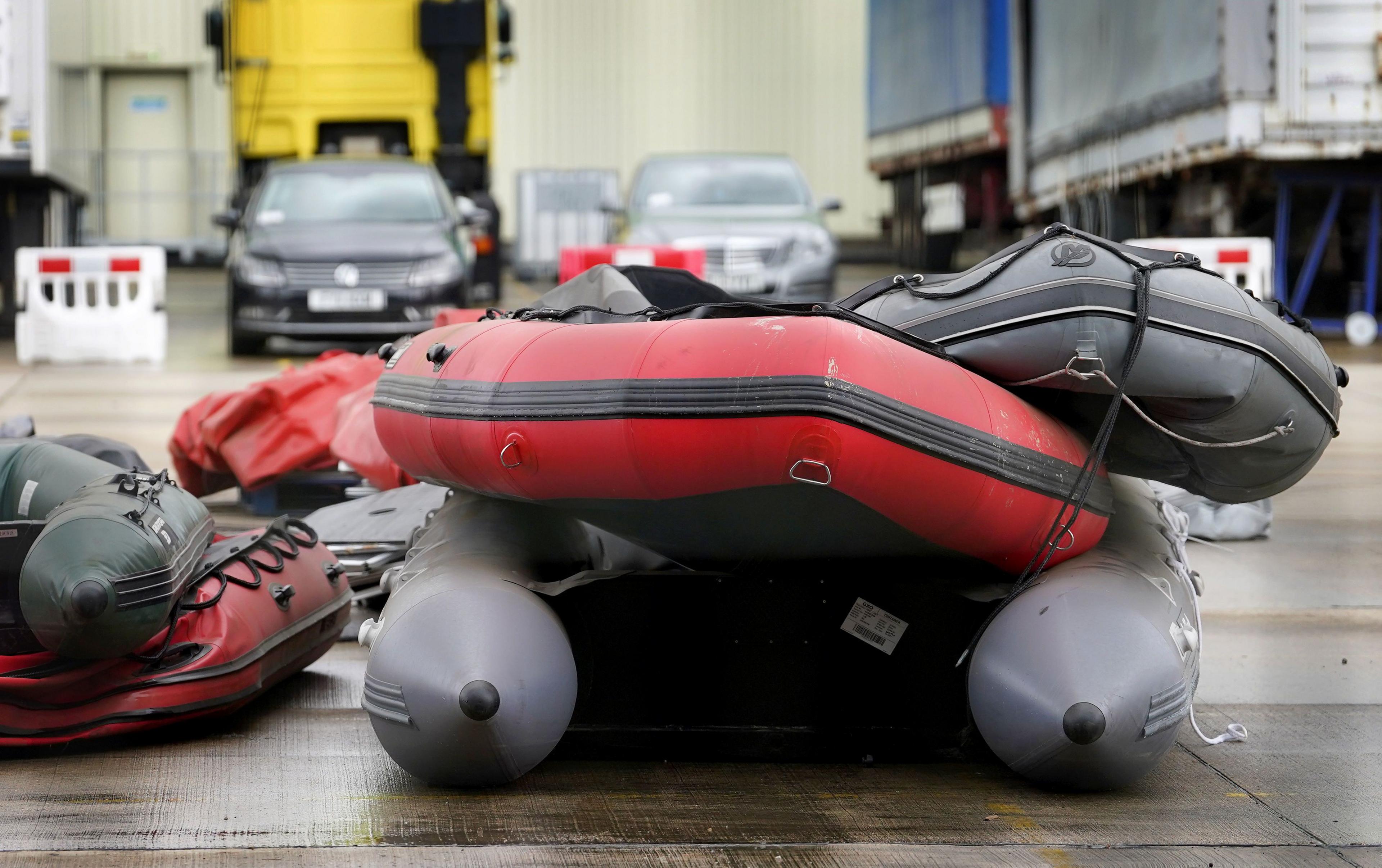 A pile of small dinghies in a storage yard.