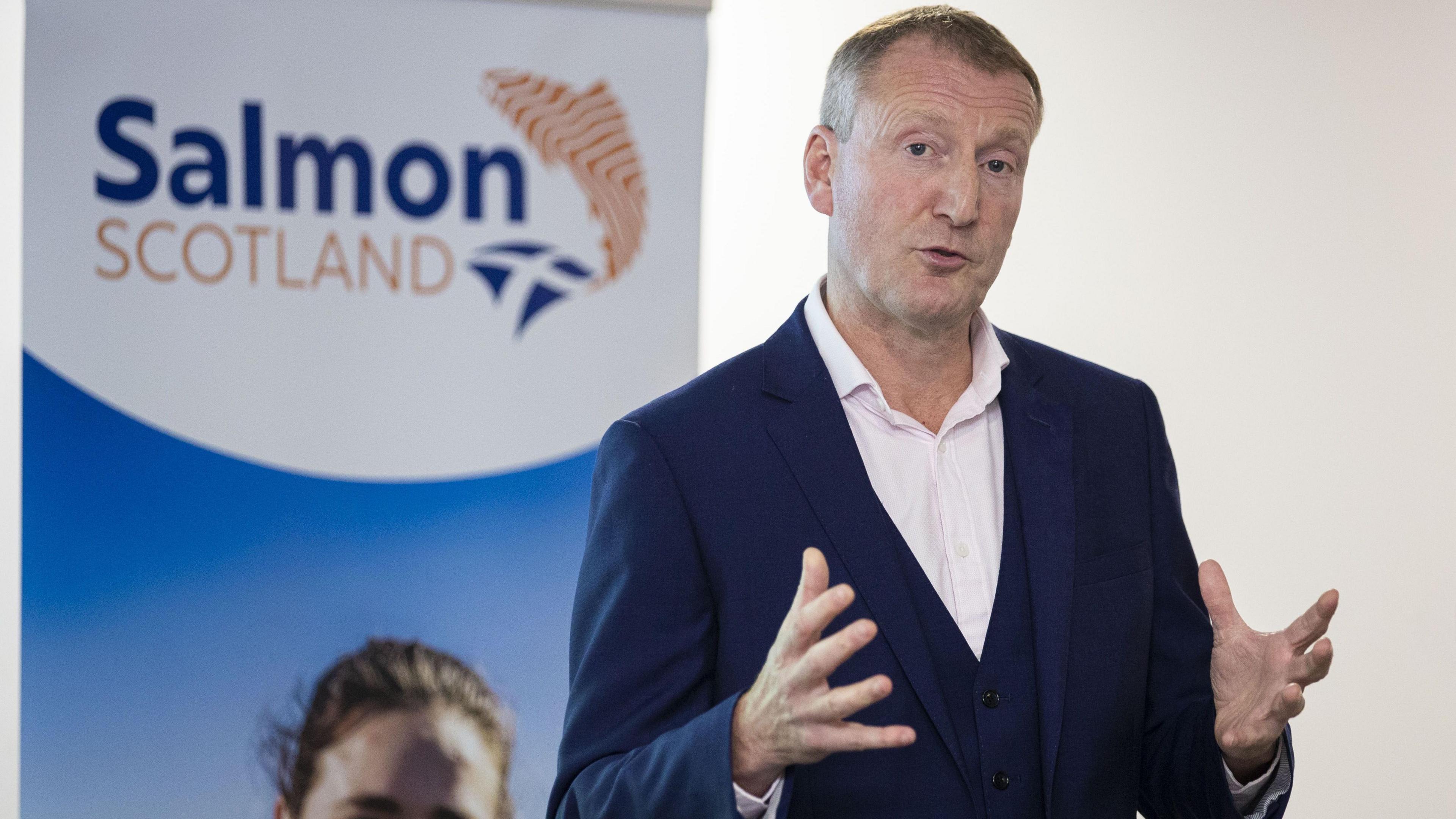 Tavish Scott, wearing a blue suit and a white shirt, looking at the camera.