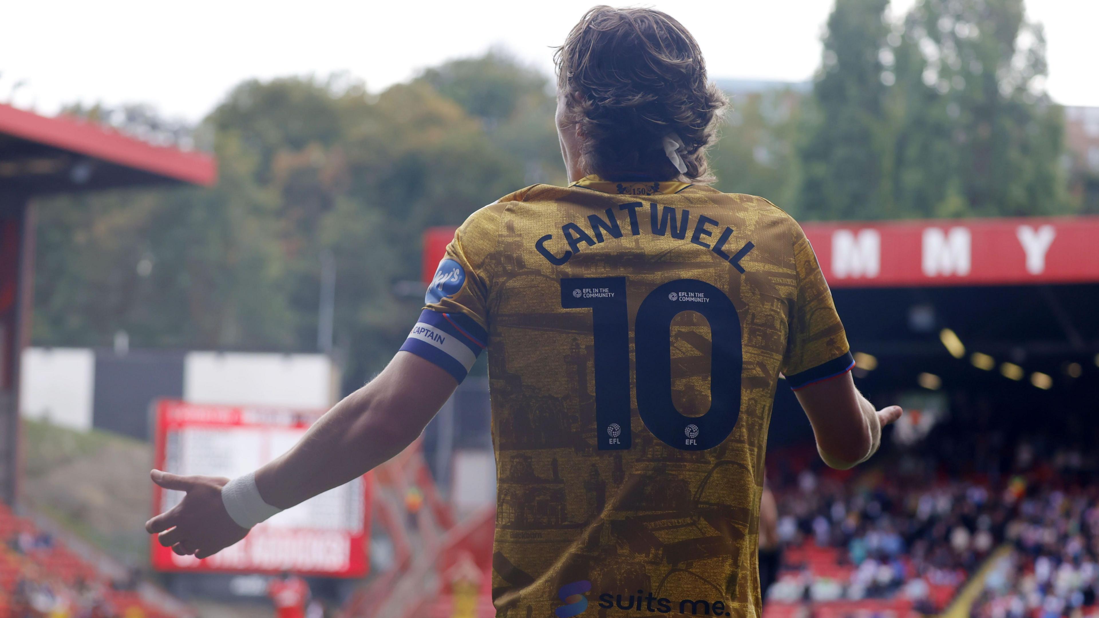 Blackburn Rovers captain Todd Cantwell holds his arms out in an appeal to the referee