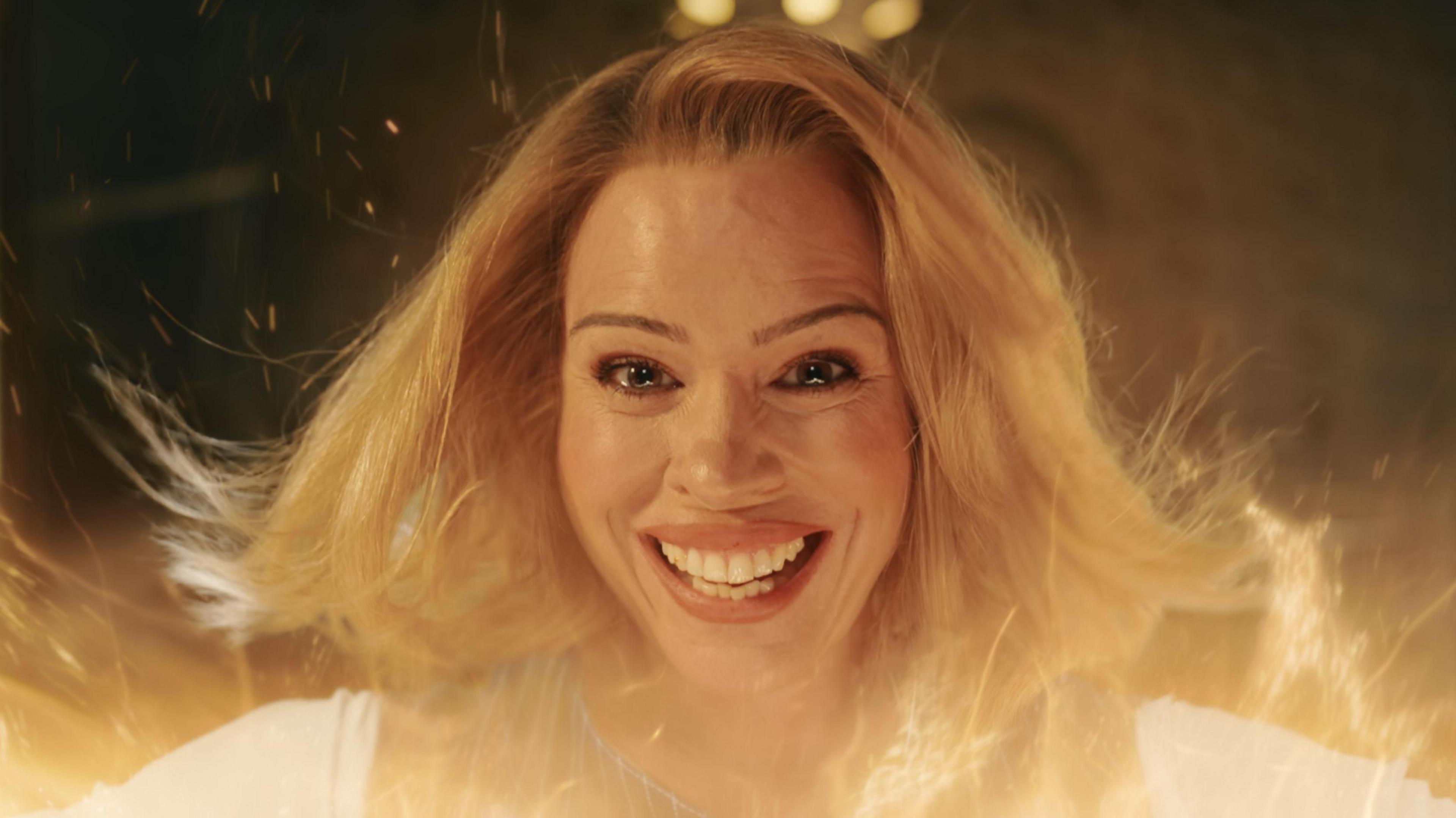 Billie Piper pictured in the final episode of Doctor Who's most recent series, smiling at the camera amidst an orange glow