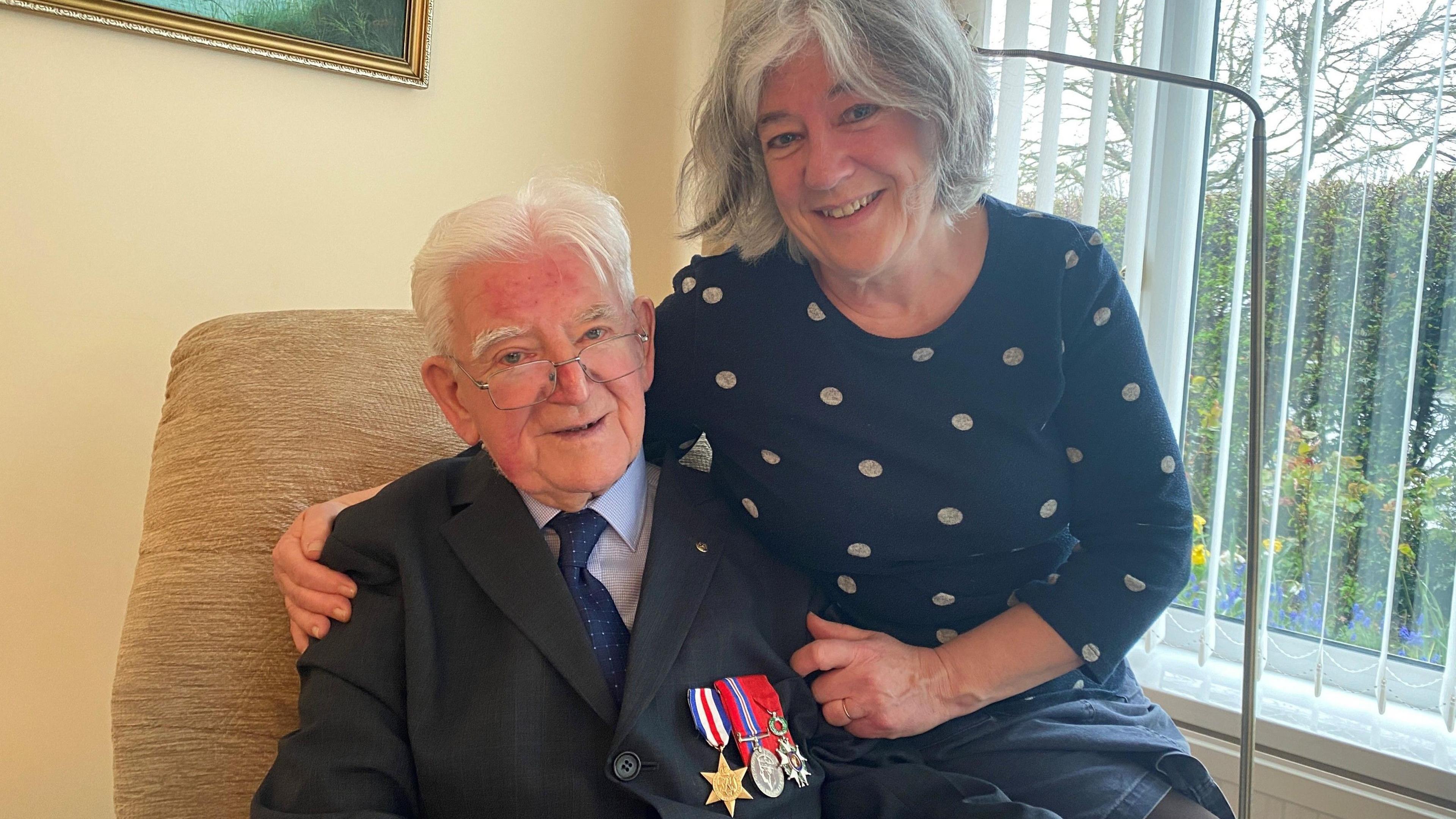 William Wake with his daughter - they are sitting in a chair and she has her arm around him 