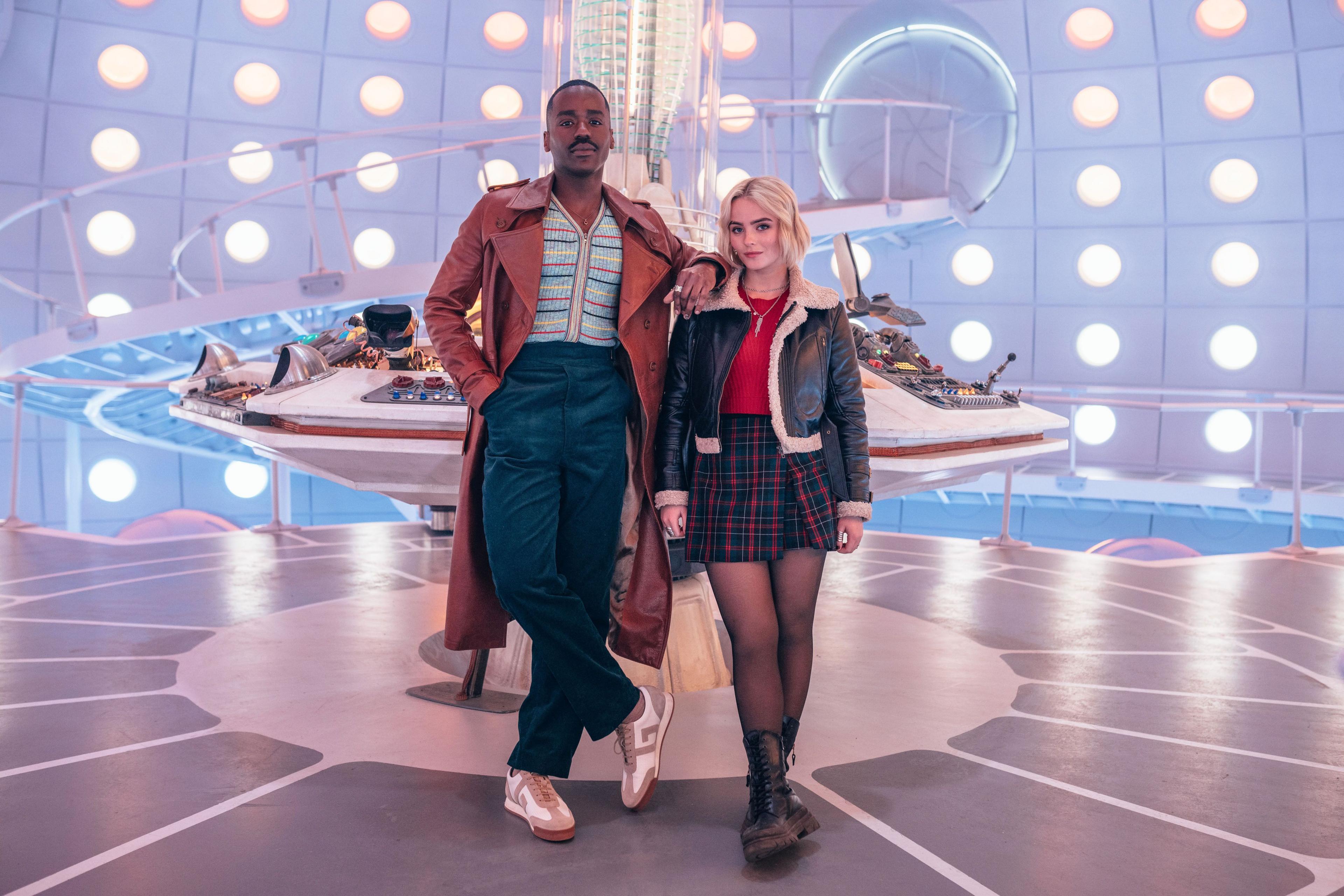 Full length publicity shot of Ncuti Gatwa and Millie Gibson in costume on the interior TARDIS set