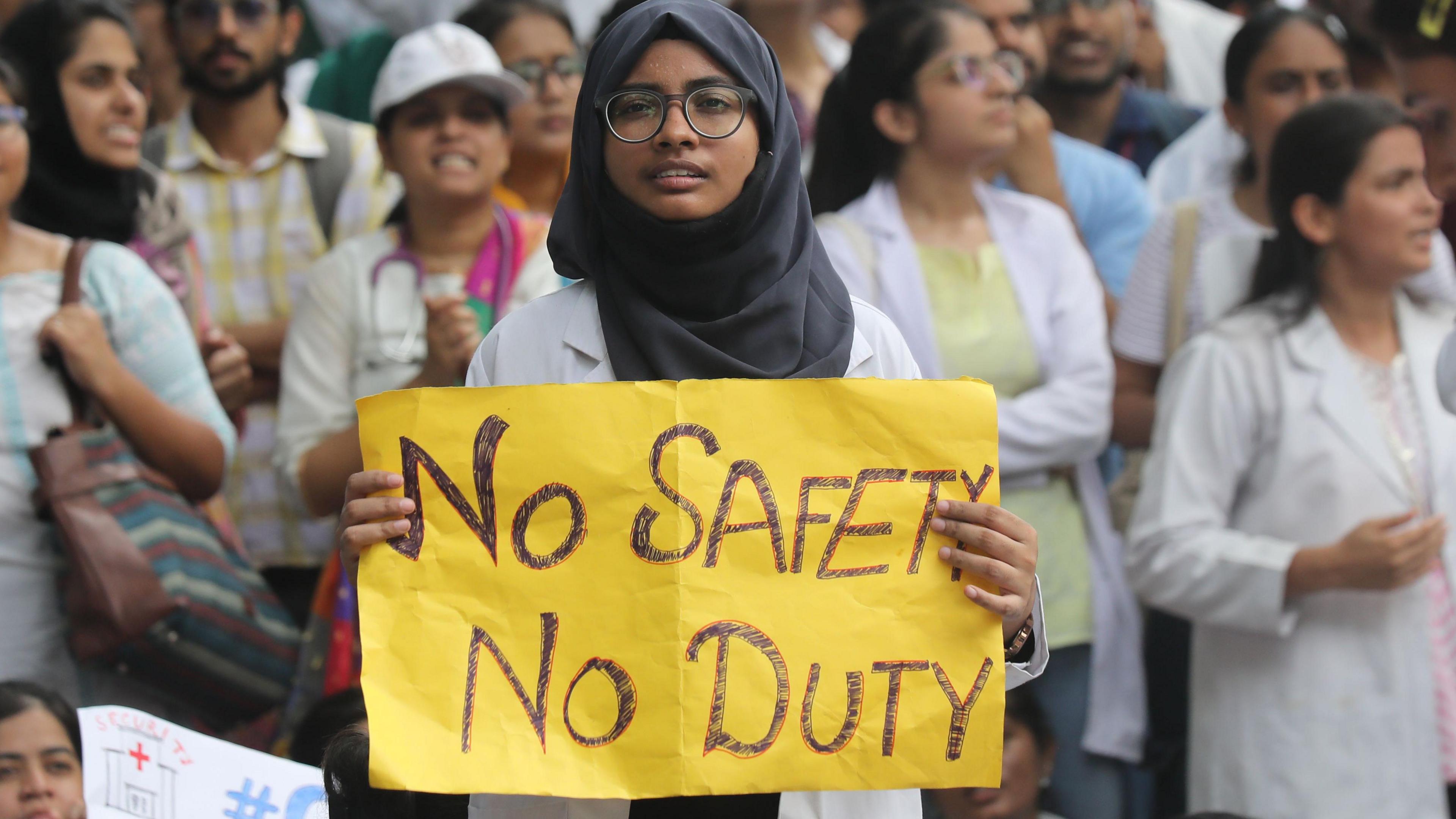 A doctor wearing a white coat, a hijab and a glasses takes part in a protest march against an alleged rape and murder incident at RG Kar medical college in Kolkata, outside Ministry of Health and Family Welfare in New Delhi, India, 16 August 2024.