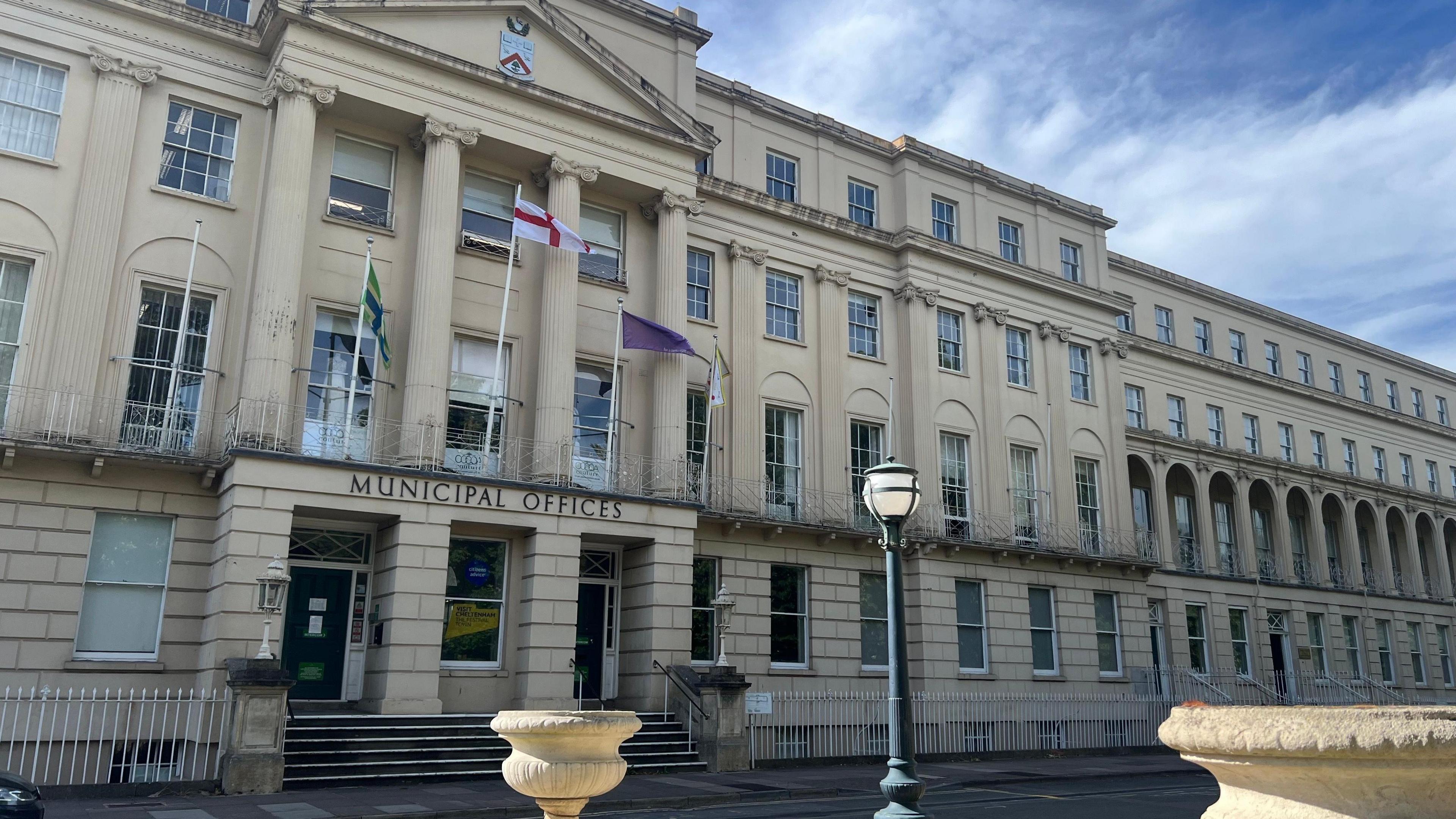 The front of Cheltenham Borough Council's civic offices. The picture shows a four-storey regency building with a sign saying "Municipal Offices". The image has been taking on a dry, cloudy day.