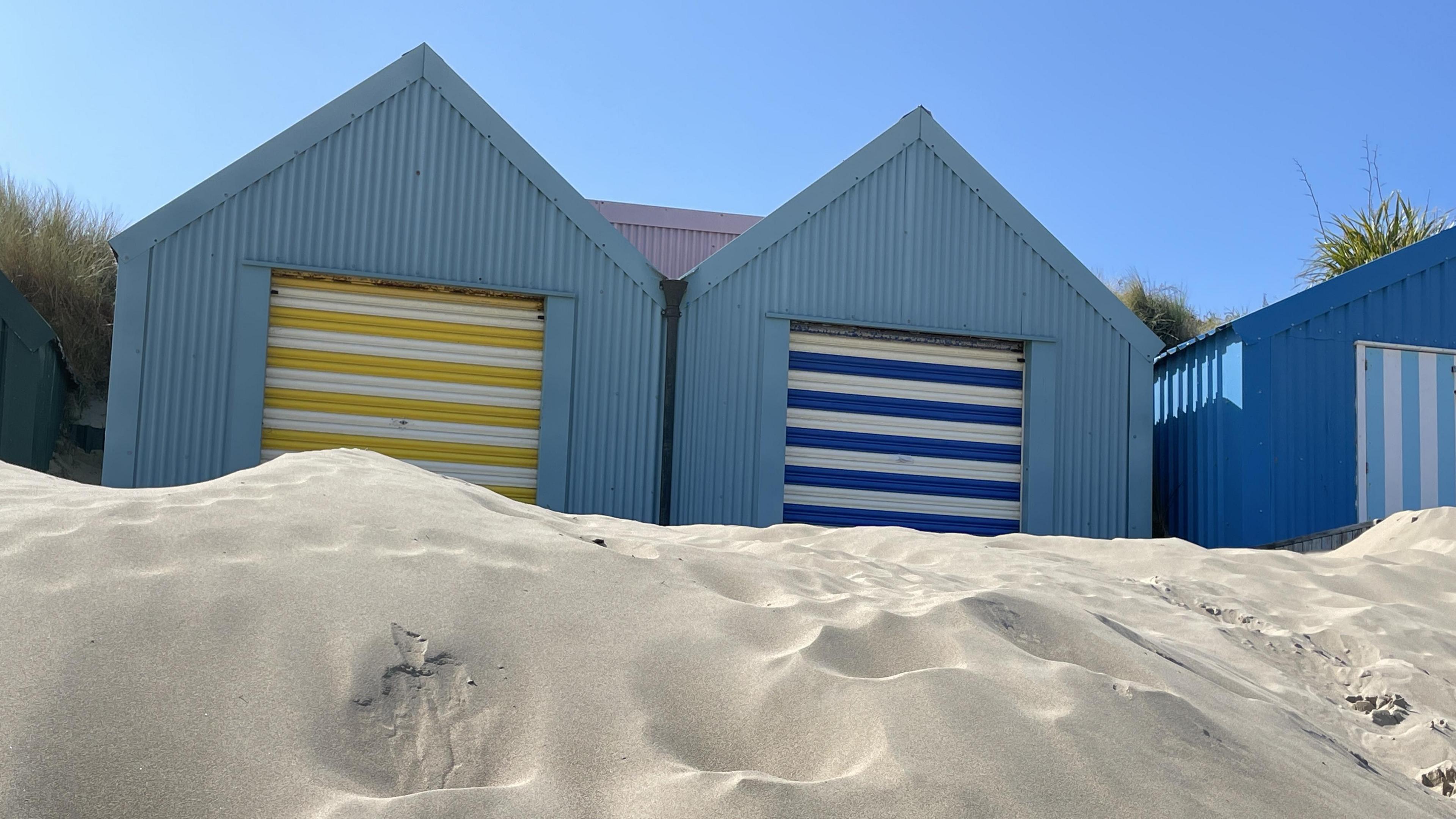 Double-fronted beach hut for sale on Porth Mawr beach in Abersoch, Gwynedd, showing it on top of a sand dune