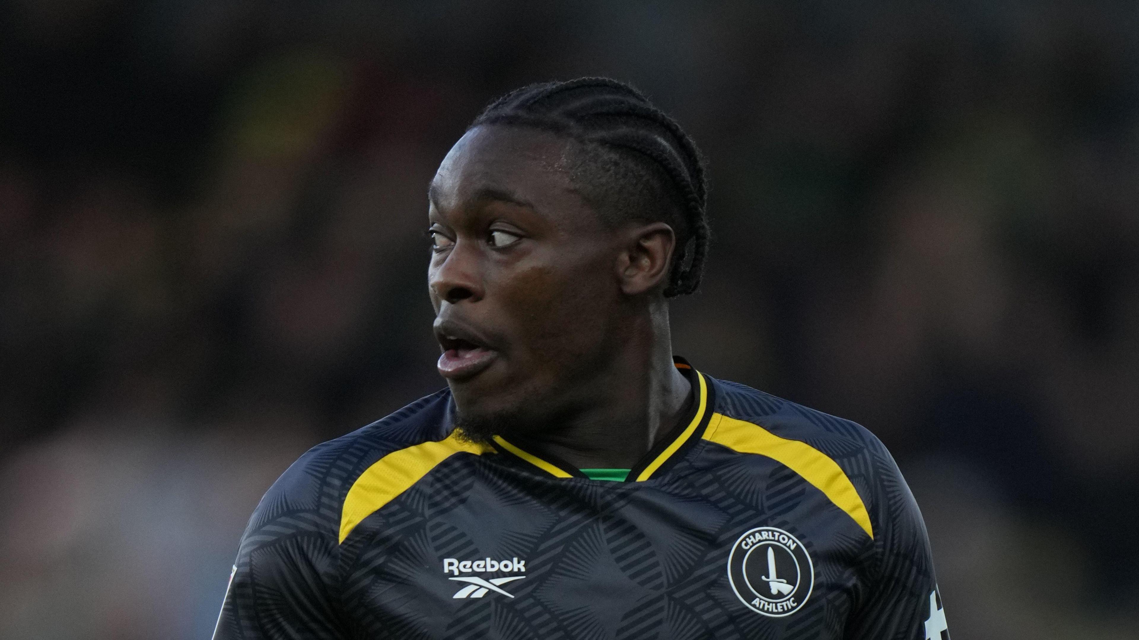 Tanto Olaofe looking to his right, playing for Charlton in a dark grey/black away kit with a yellow trim