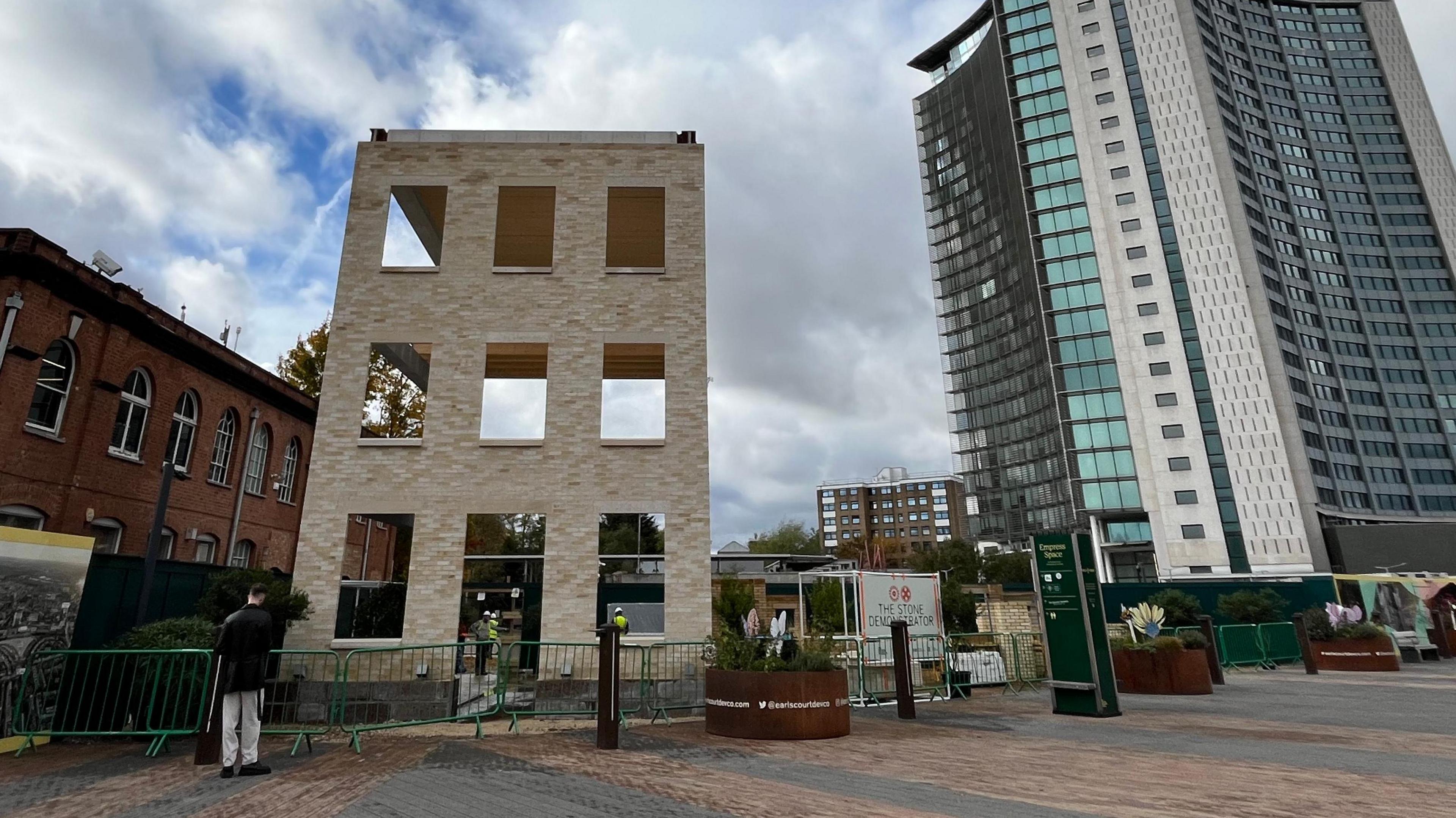 A stone structure has been built next to a modern tower block