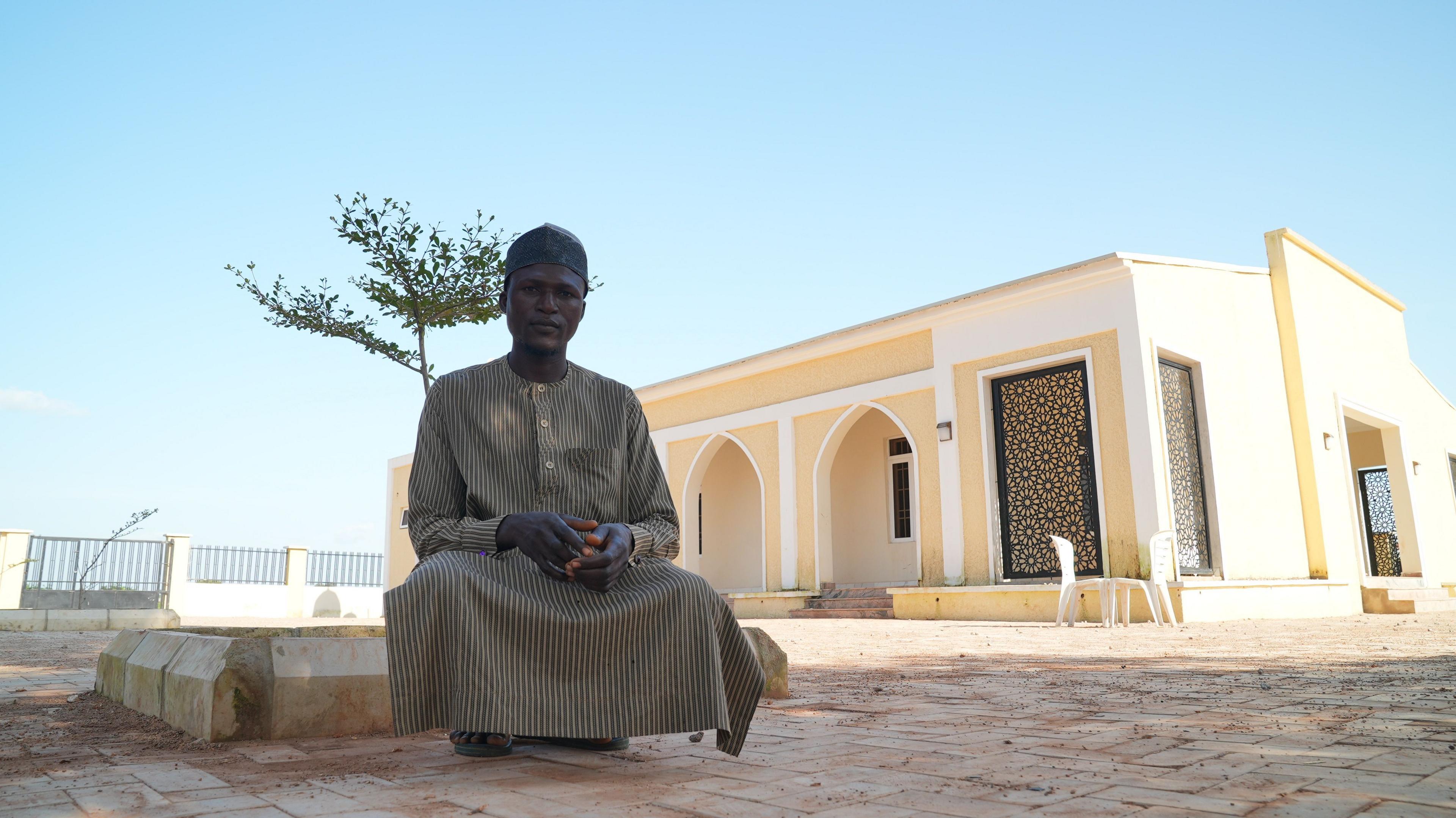 Masud Abdulrasheed, sitting outside the new mosque in the village