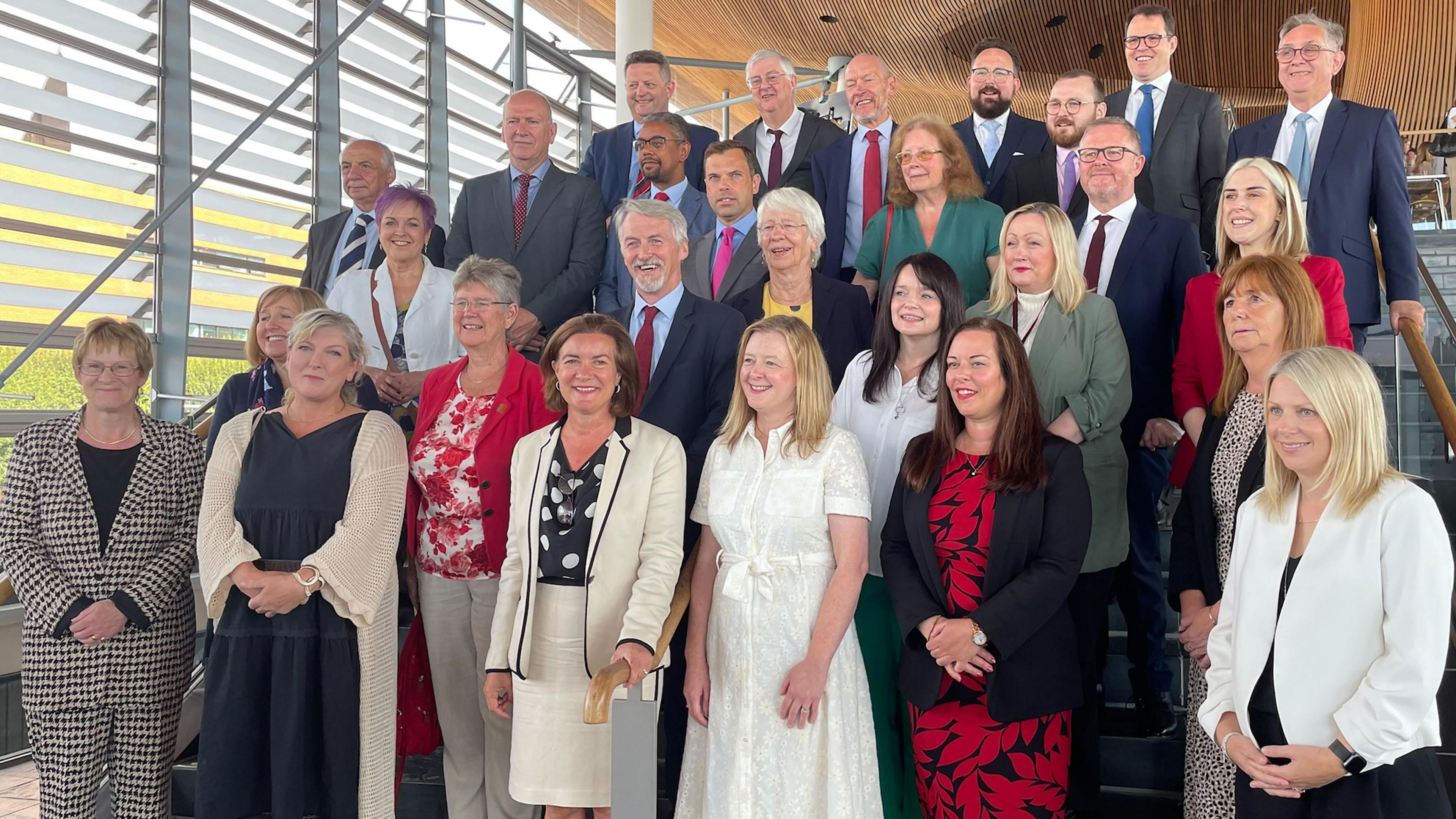 Eluned Morgan surrounded by Labour MSs on steps inside the Senedd building