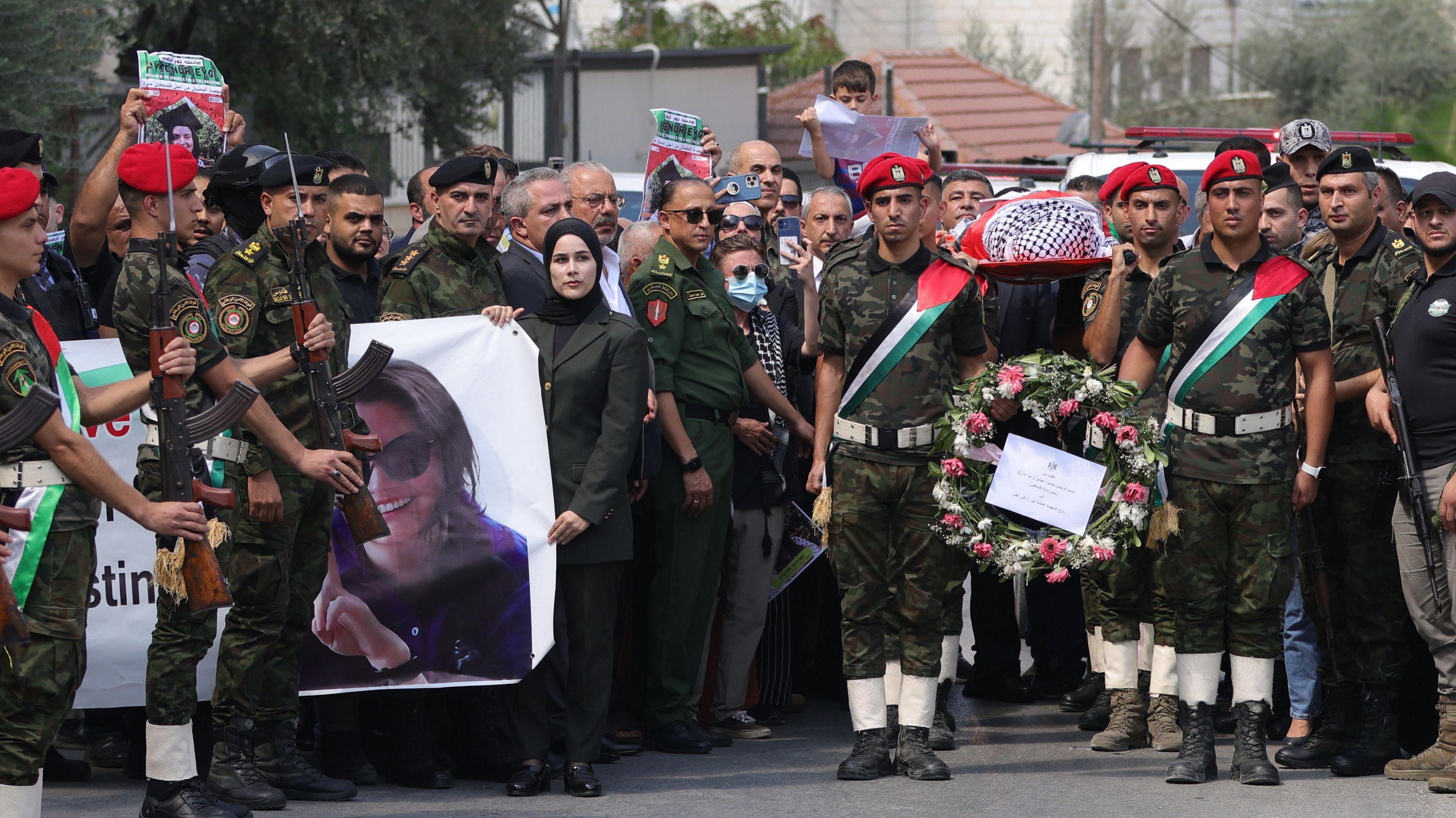 Palestinian honour guards hold aloft the wrapped body of Ms Eygi on a stretcher amid a crowded turnout for her funeral procession in Nablus on 10/9/2024.