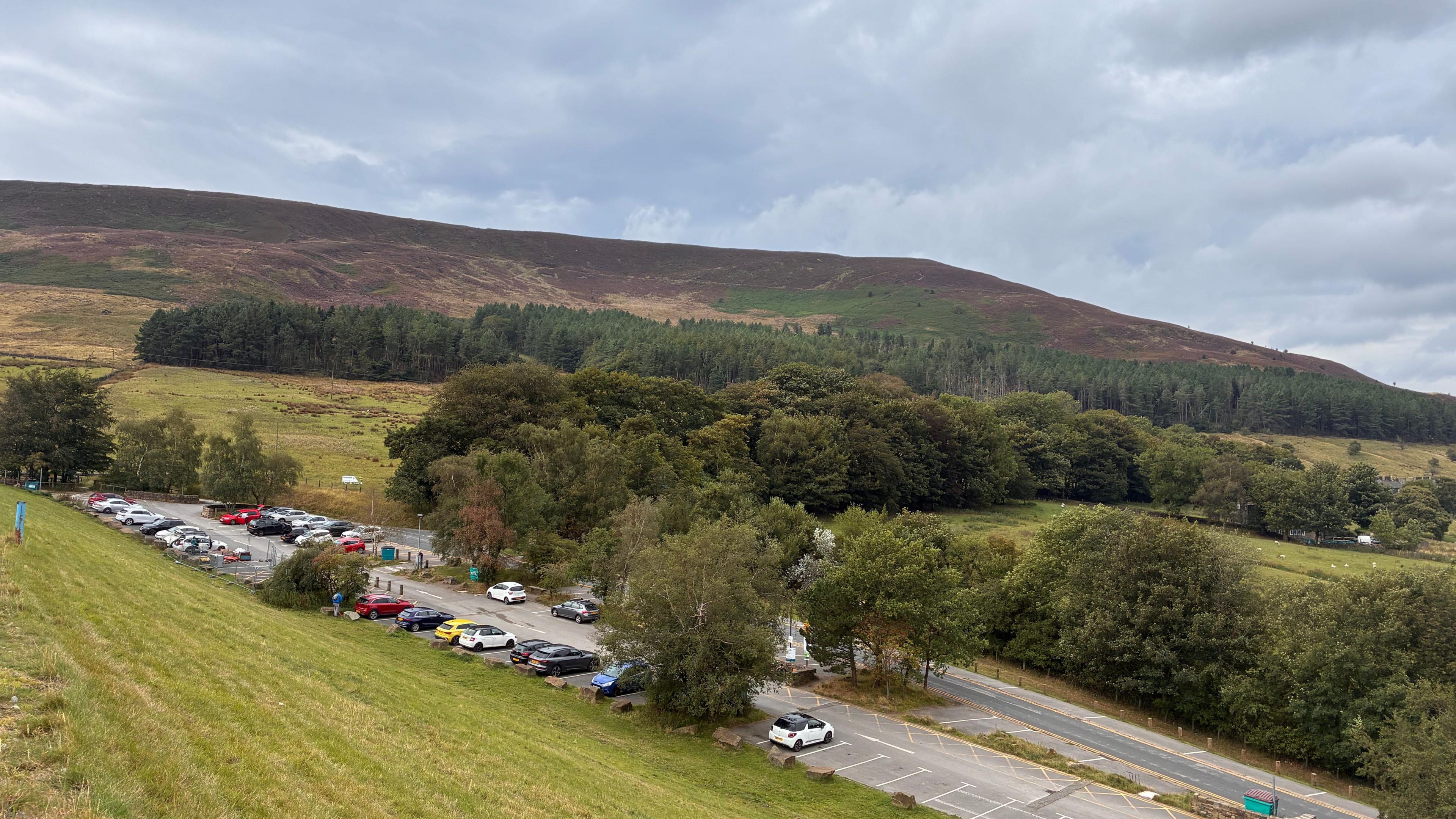 An aerial view of a country car park surrounded by greenery and trees
