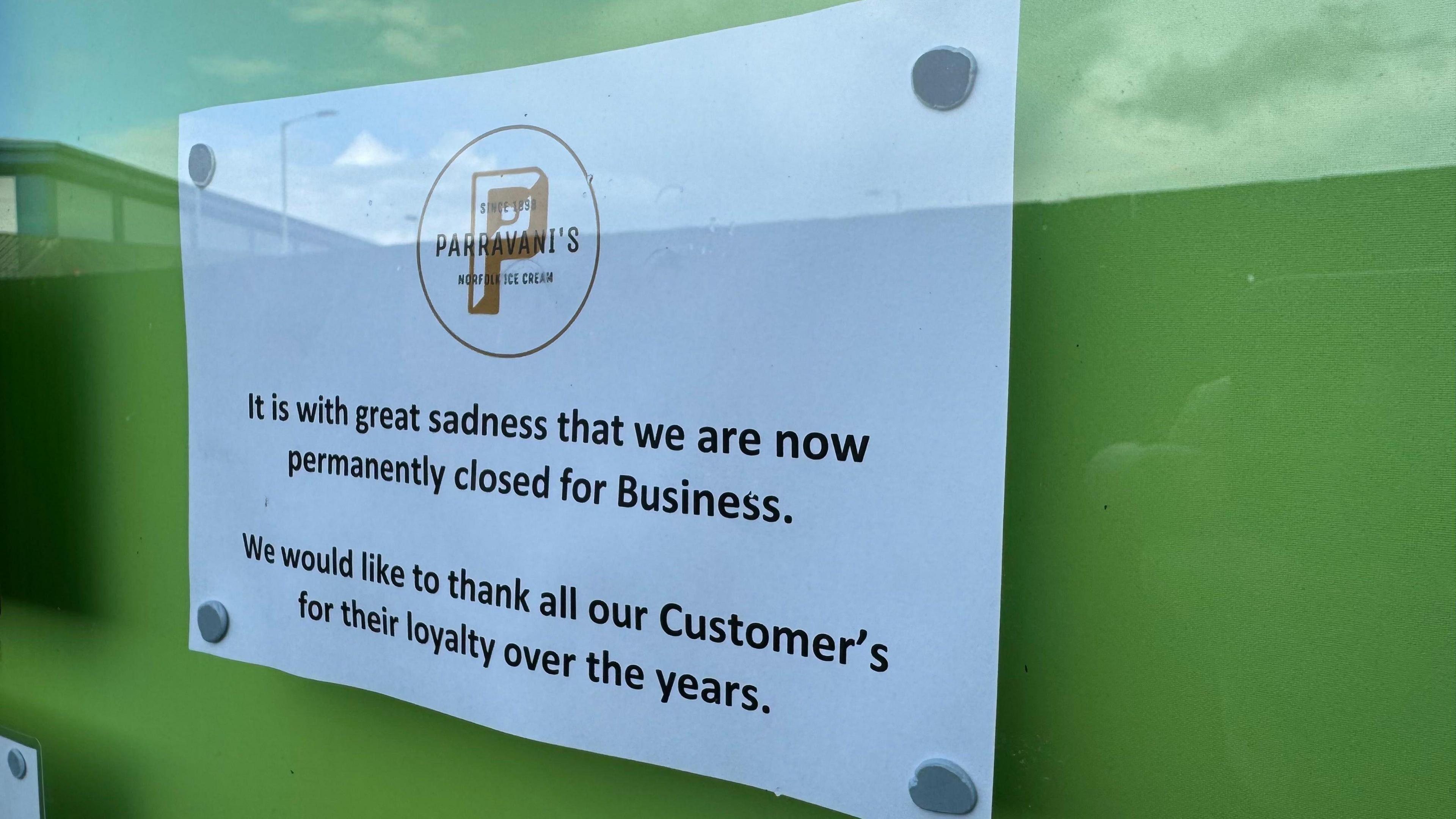 A white piece of paper stuck on a window with the words "It is with great sadness that we are now permanently closed for business. We would like to thank all our customers for their loyalty over the years".