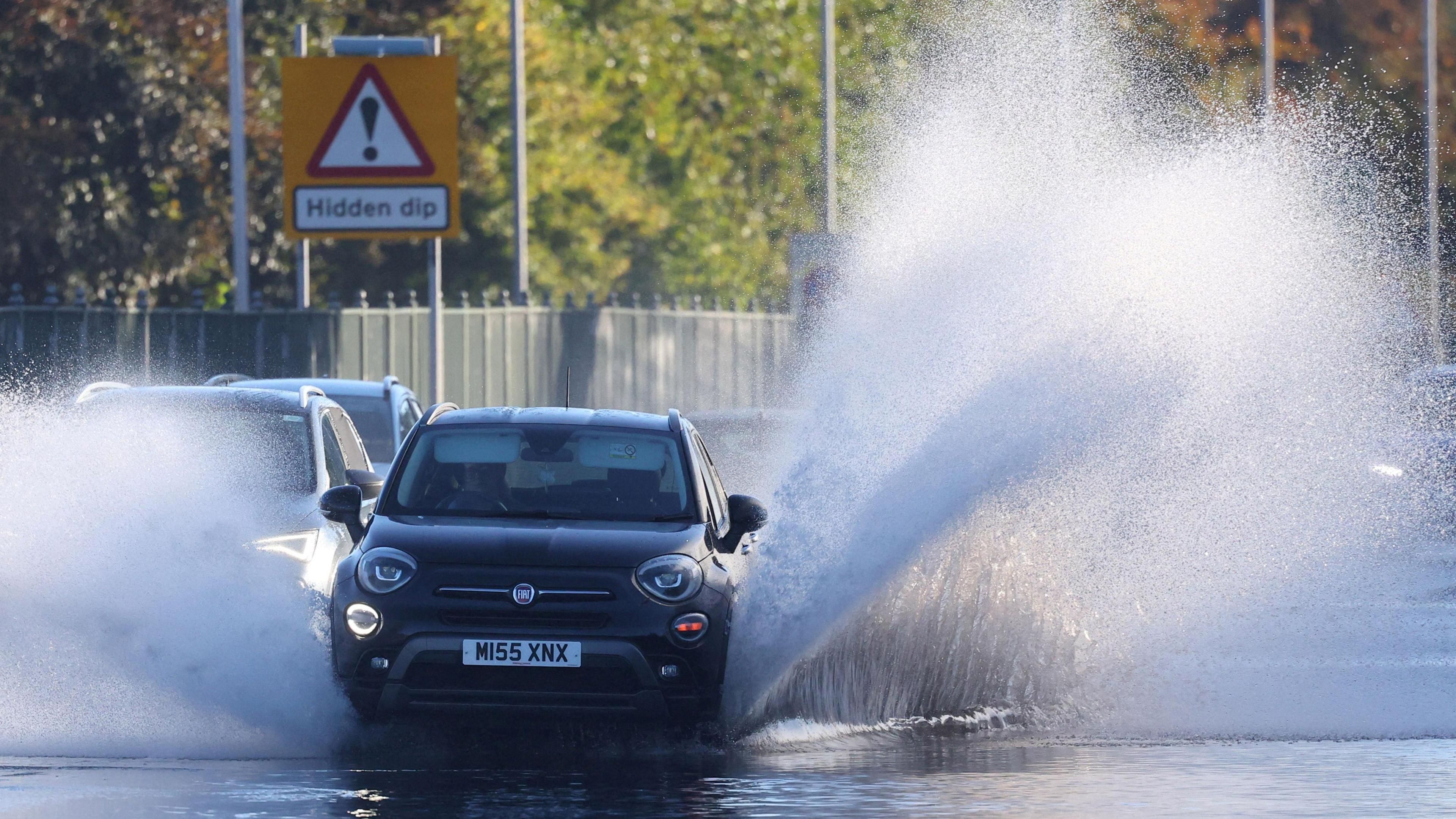 Car driving through flooded road in southwest London