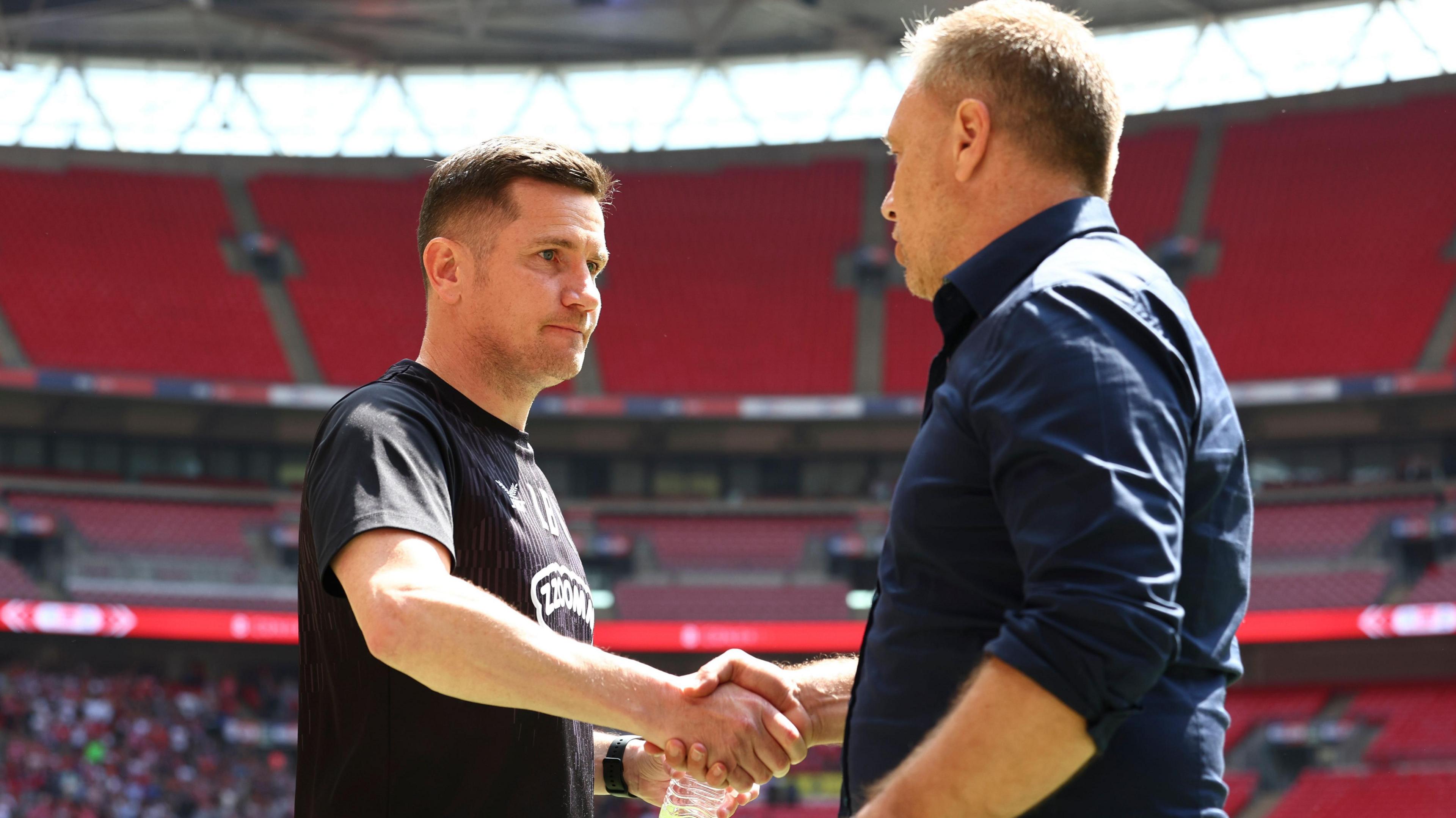 Crewe boss Lee Bell shakes hands with Crawley manager Scott Lindsey