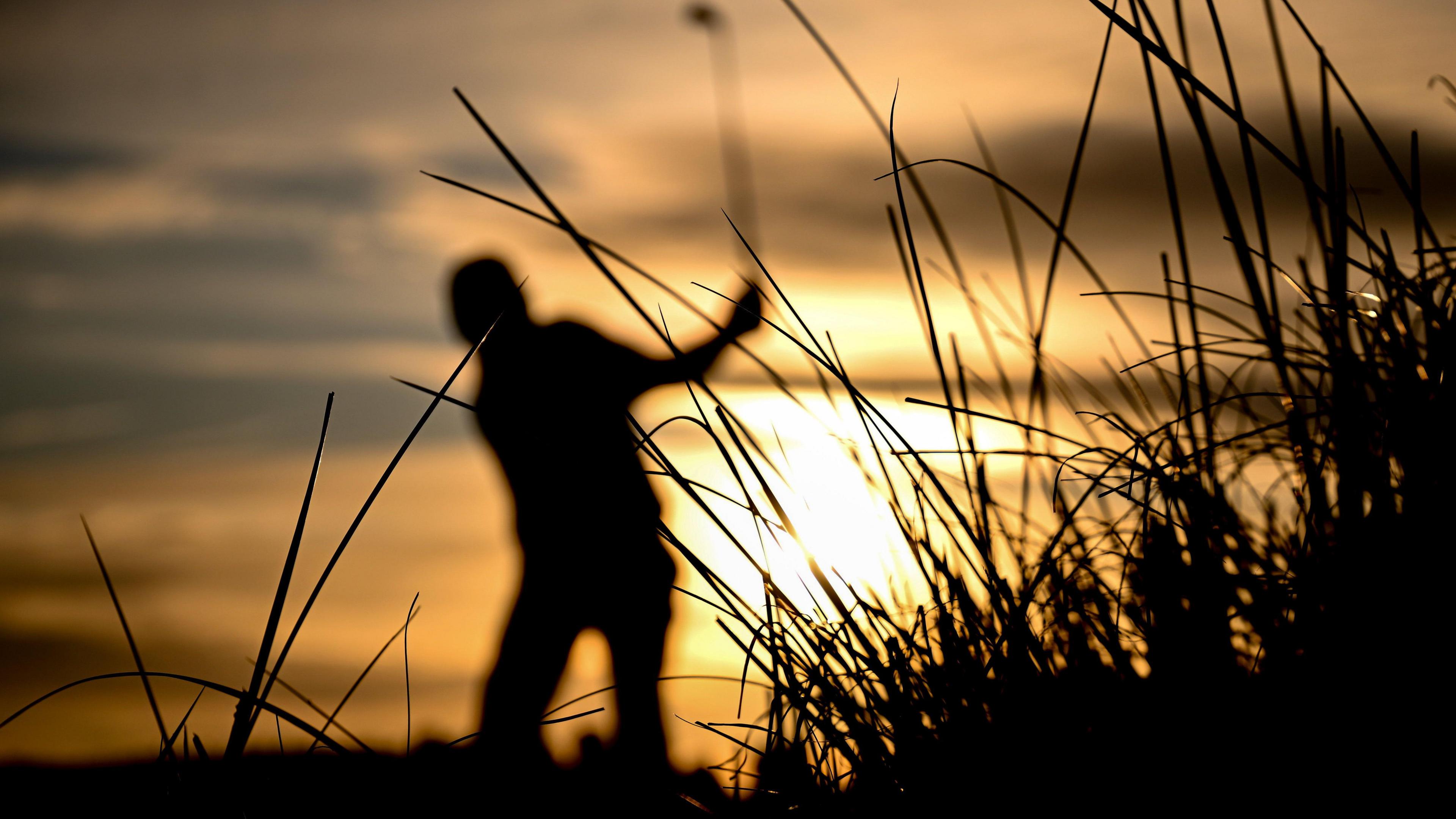 Silhouette of a golfer hitting a shot