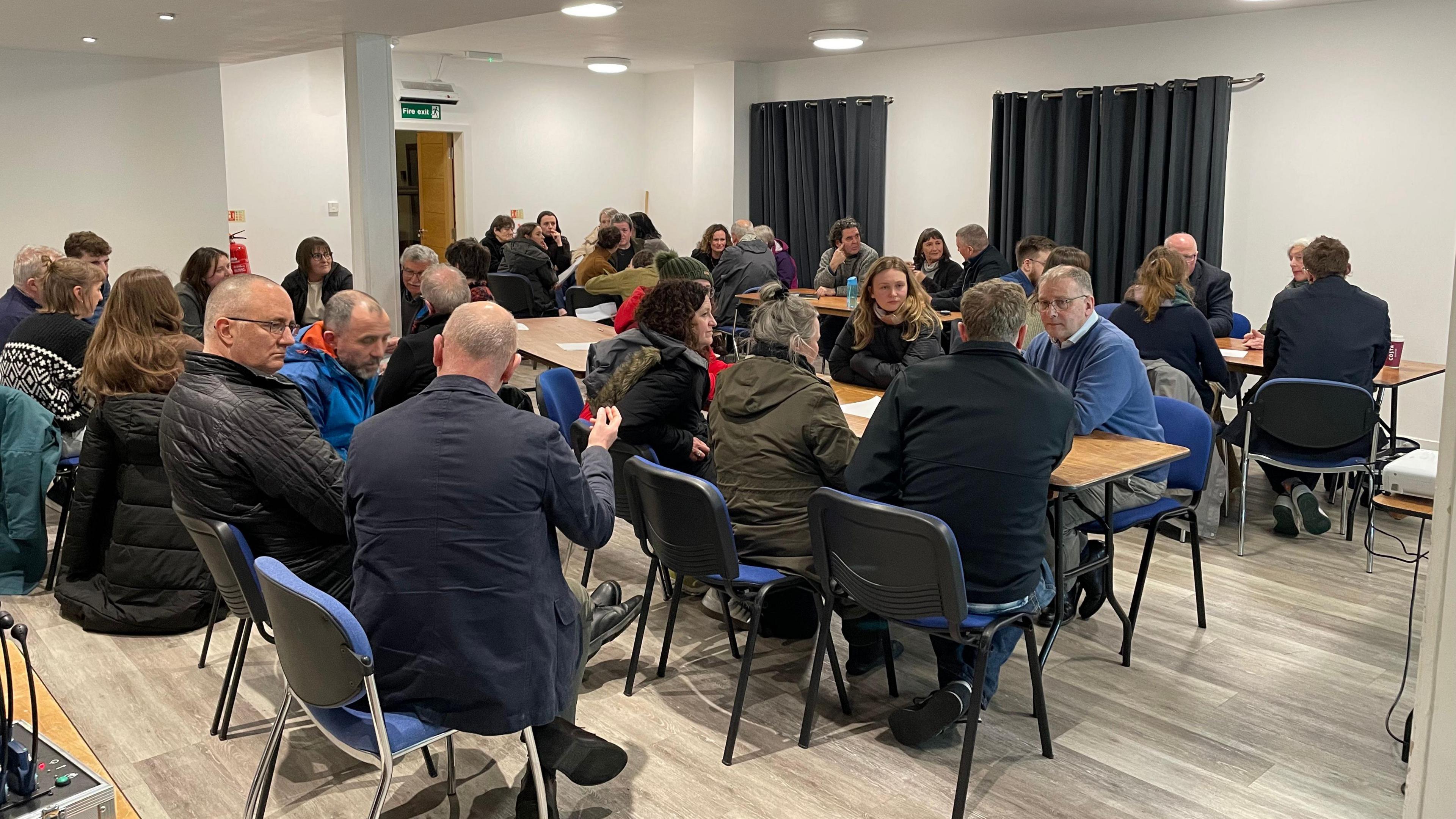 Daoine a' deasbad aig a' choinneimh ann am Port Rìgh oidhche Dhiardaoin