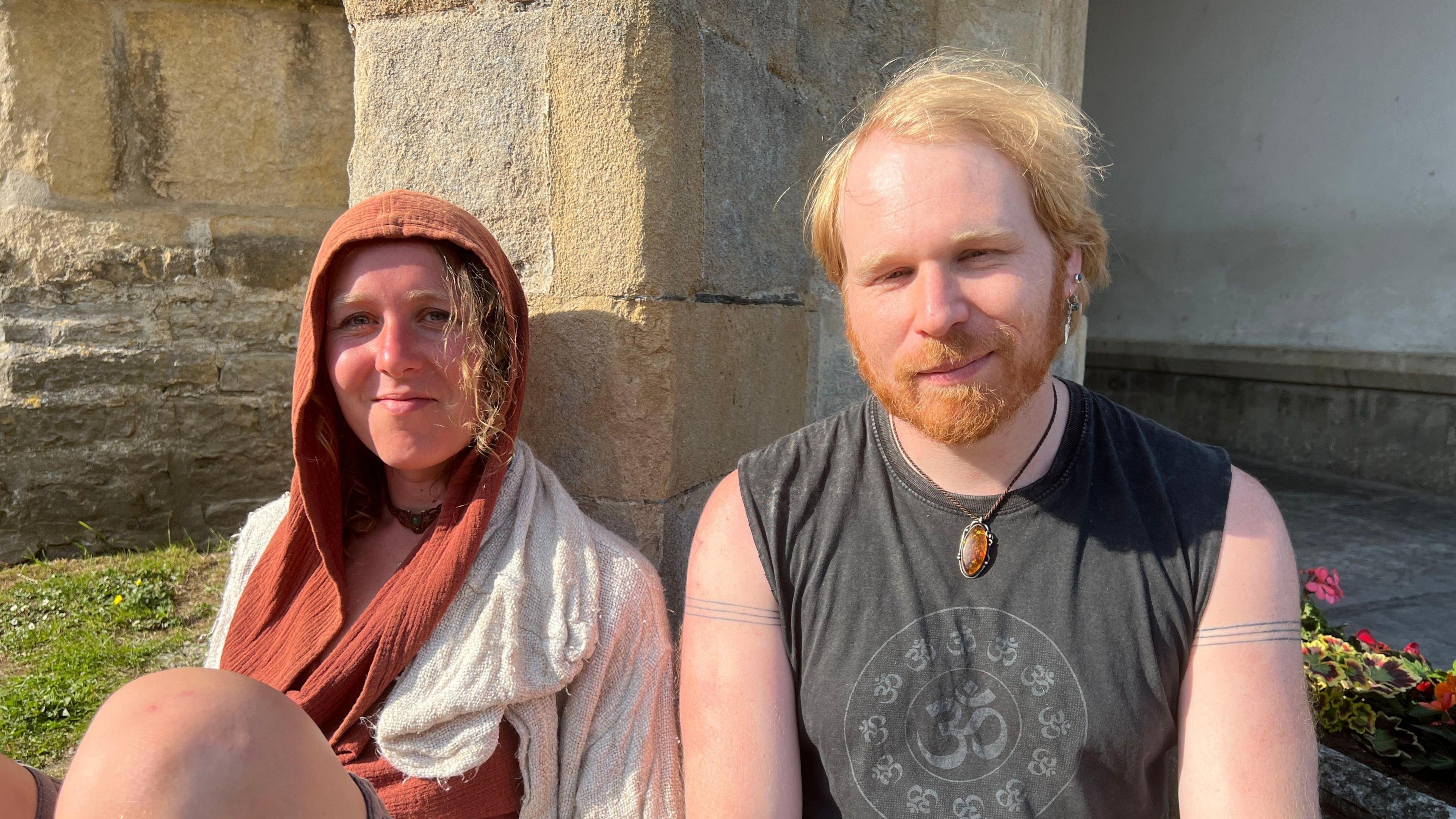 Ginger-haired man on the right in a black top. He's sat next to a women with a headscarf and long hair.