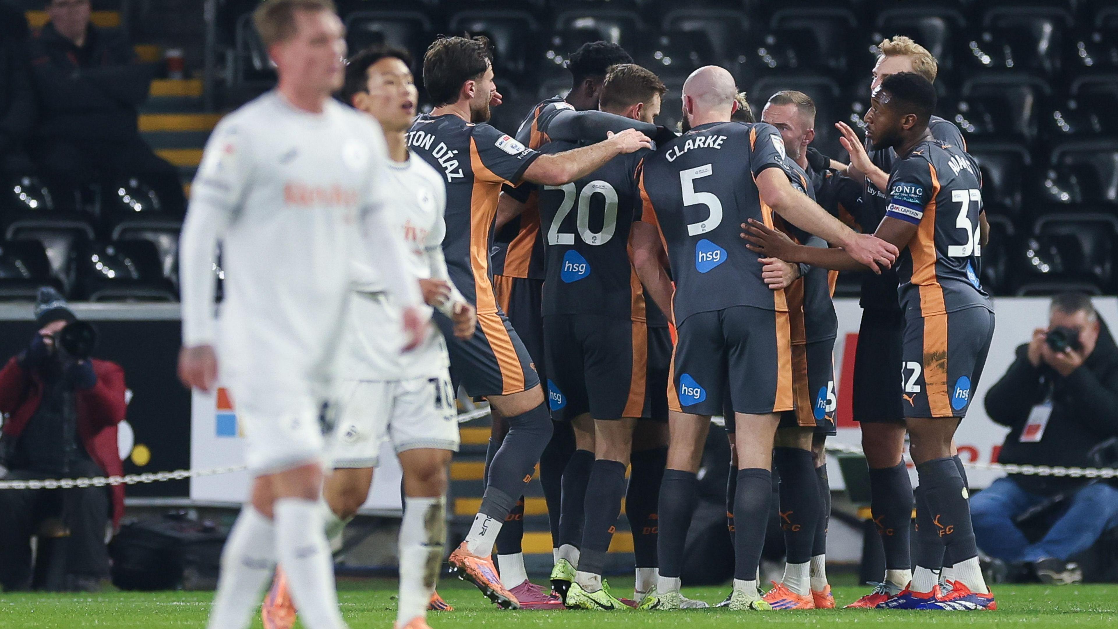 Swansea players looked dejected as Derby players celebrate 