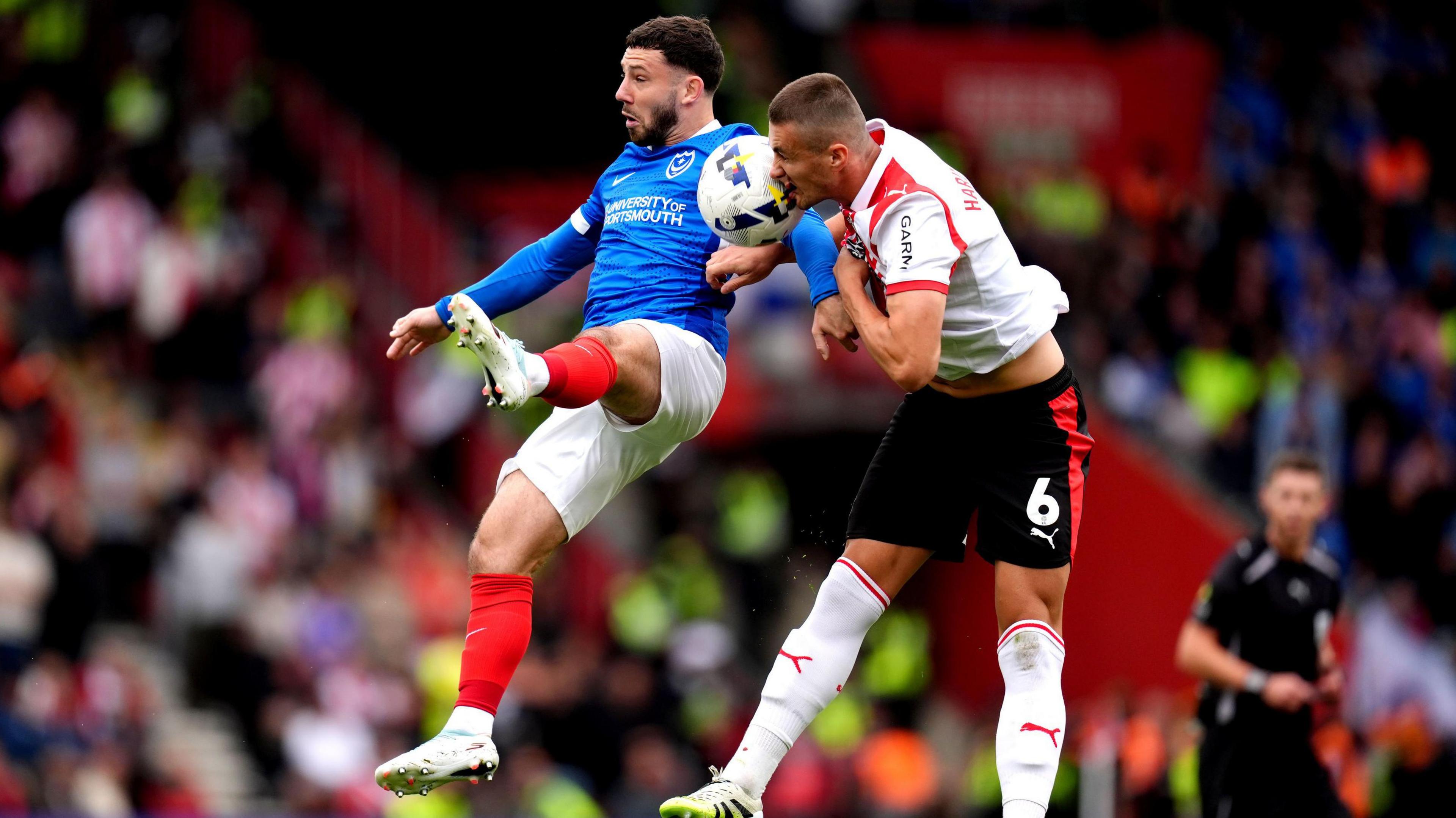 Portsmouth's Conor Chaplin battles for possession of the ball in the air with Southampton's Taylor Harwood-Bellis during the match at St Mary's Stadium, Southampton.