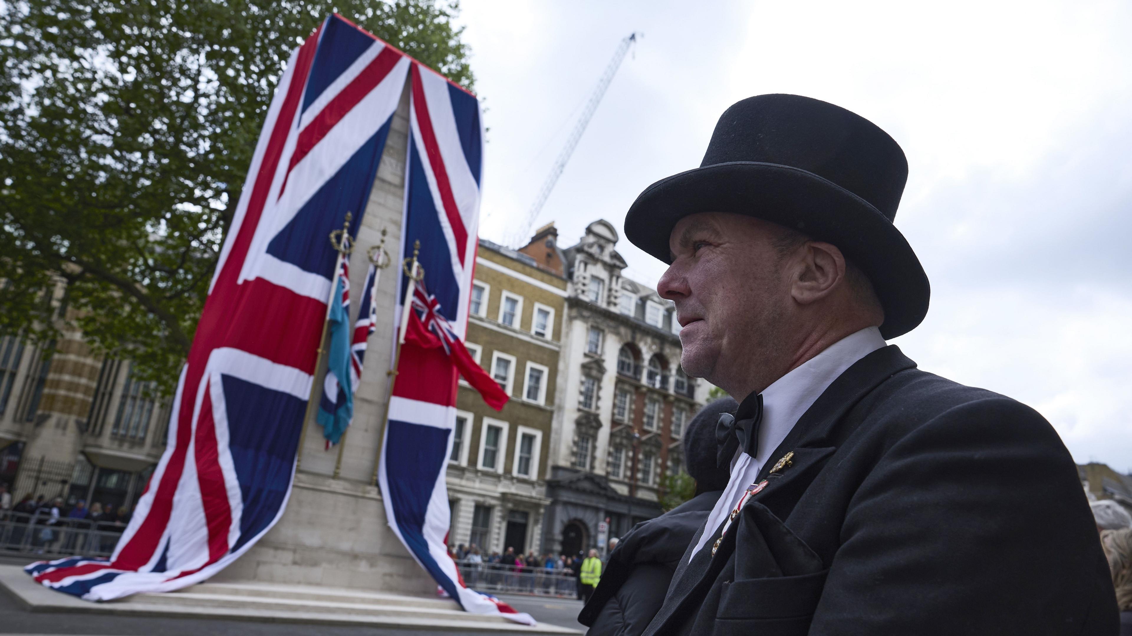 An image of the Cenotaph in London during VE Day 80 celebrations. A man with a top hat stands to the right side.
