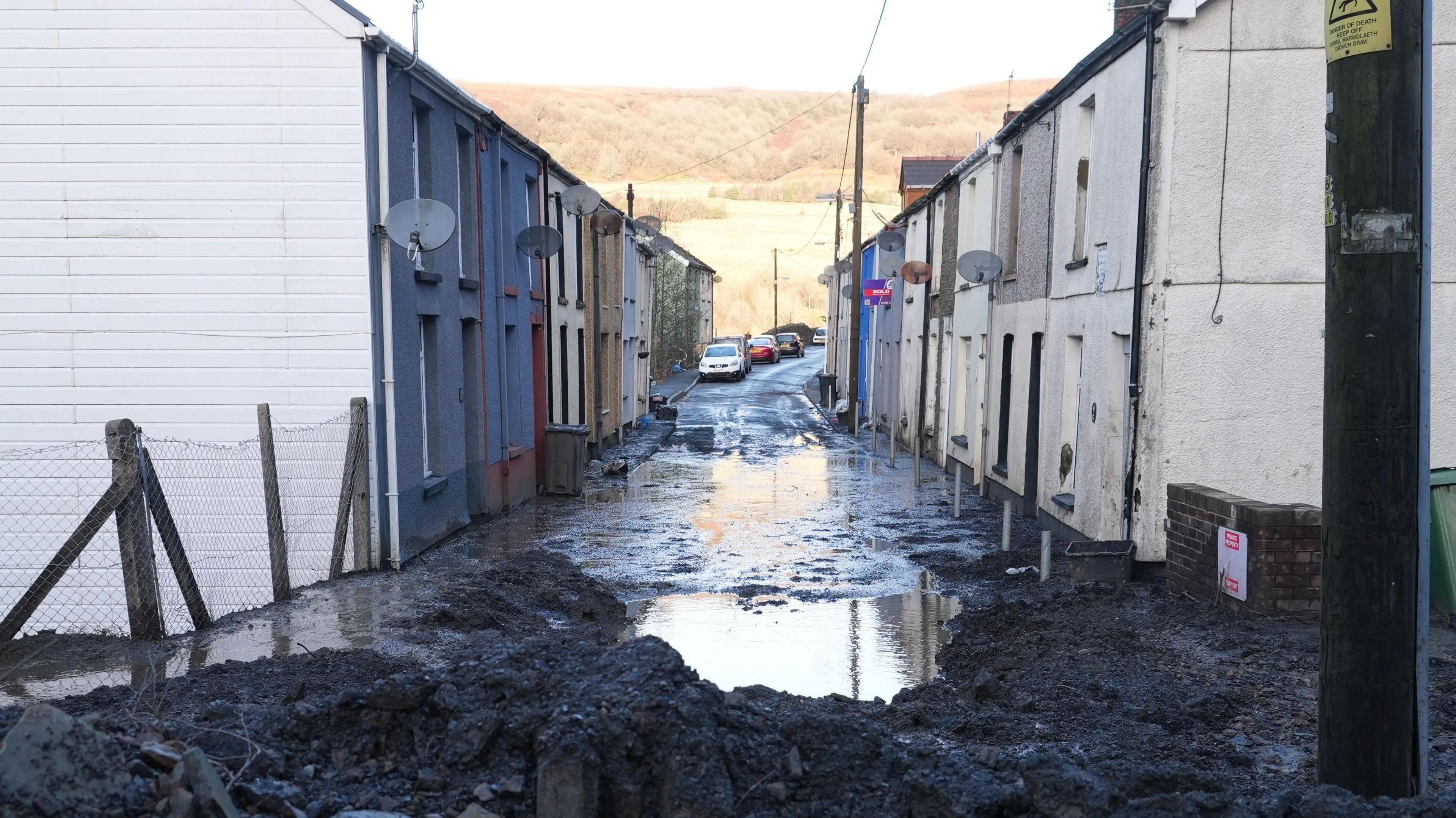 Black sludge and mud piled high at the end of a street in Cwmtillery