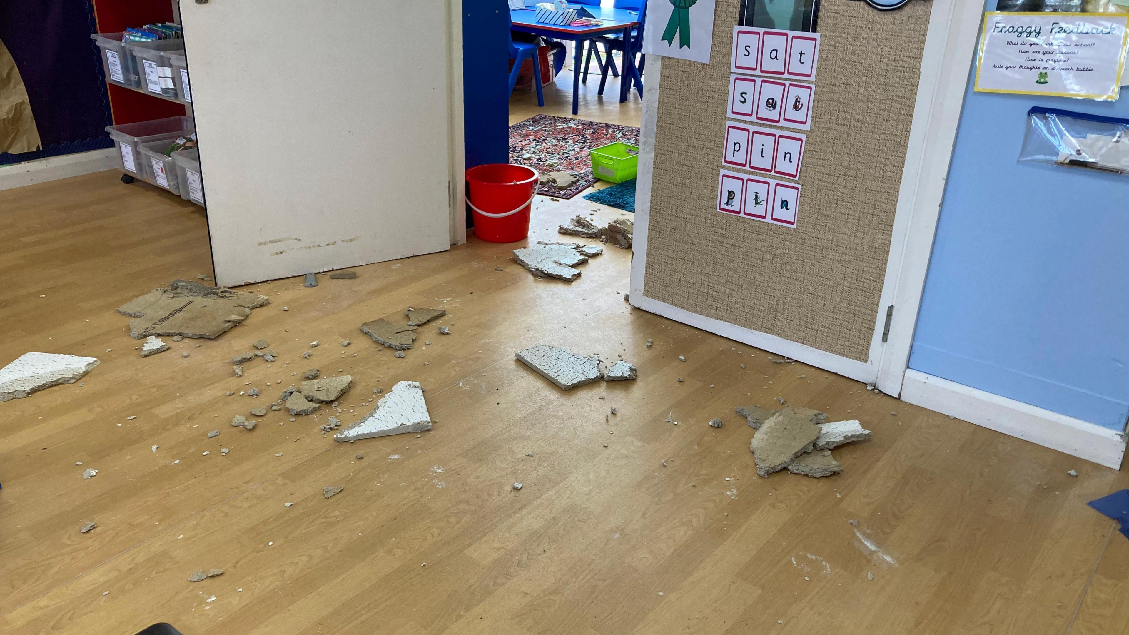 Broken pieces of tile on a wooden floor in a school