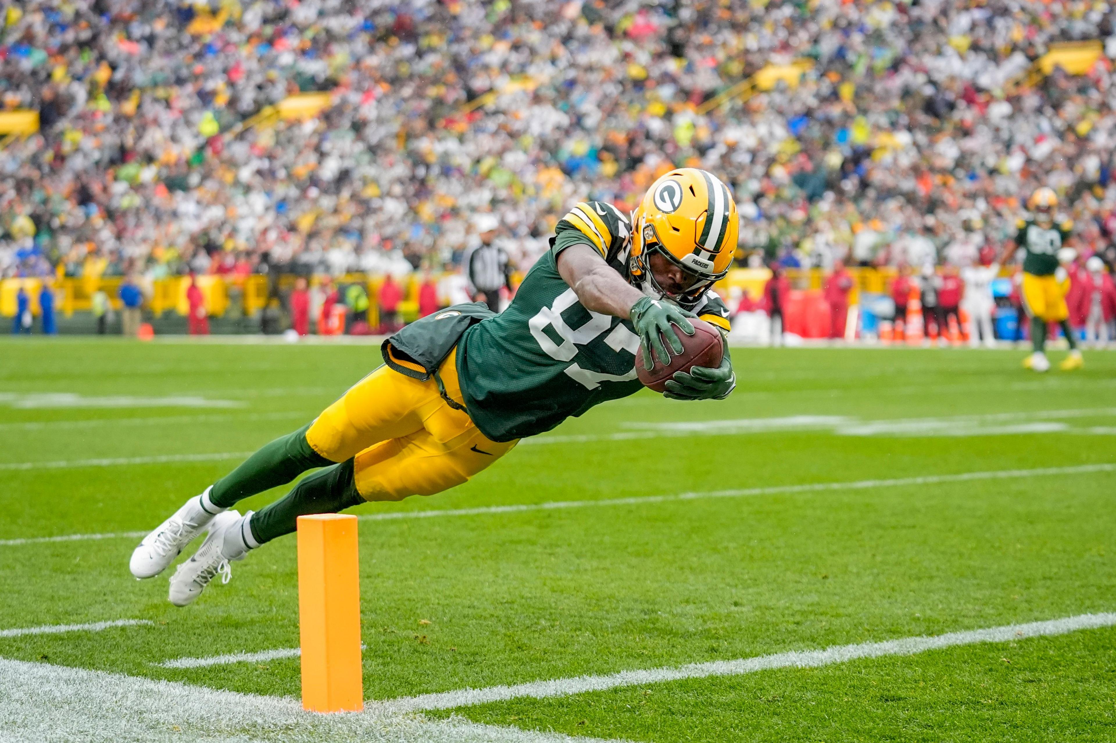 Romeo Doubs dives into the end zone to score a touchdown for the Green Bay Packers against the Arizona Cardinals