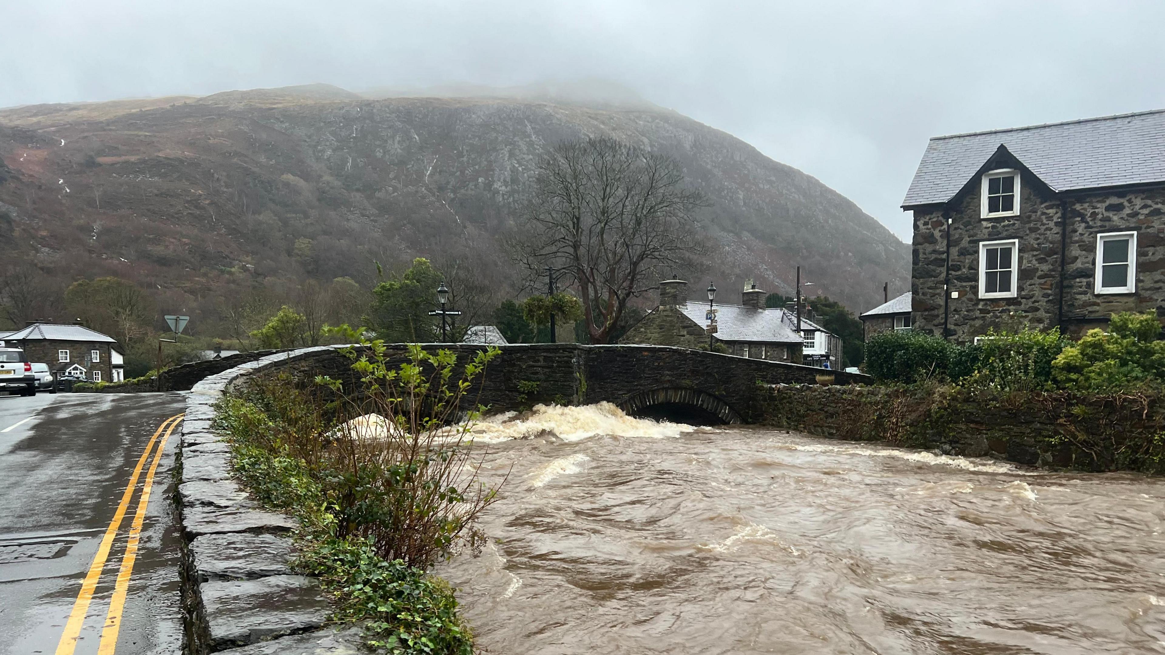 River level almost reaching the roof of a road bridge at Beddgelert, Gwynedd