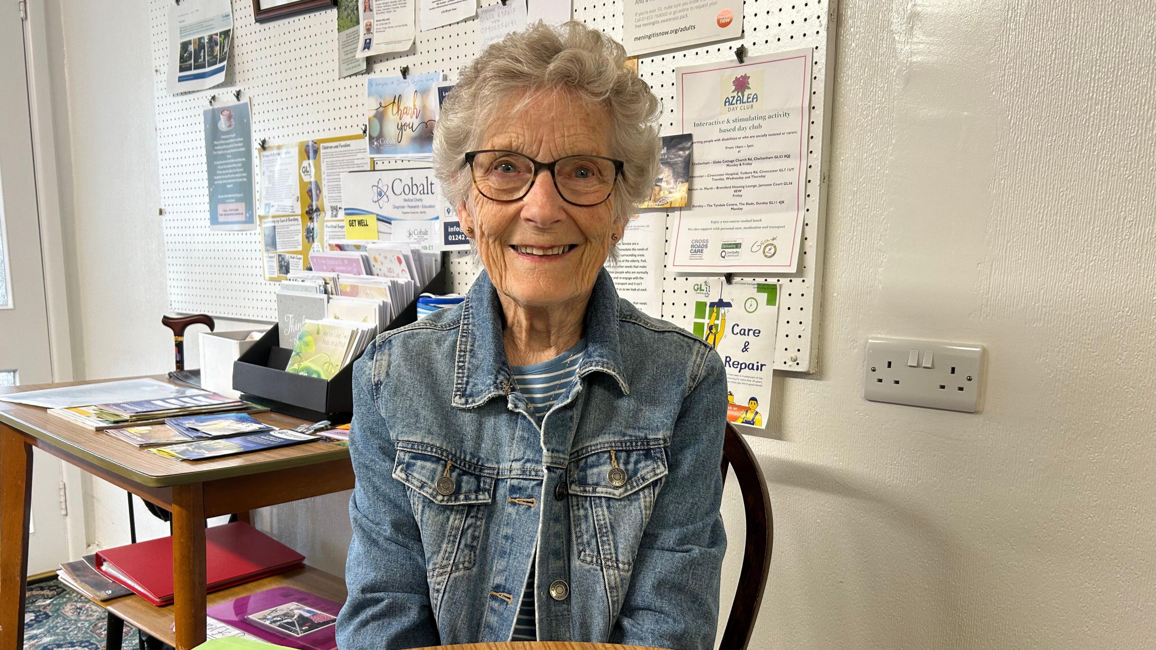 Pam Uglow smiling as she sits on a dining chair at Dursley Day Centre